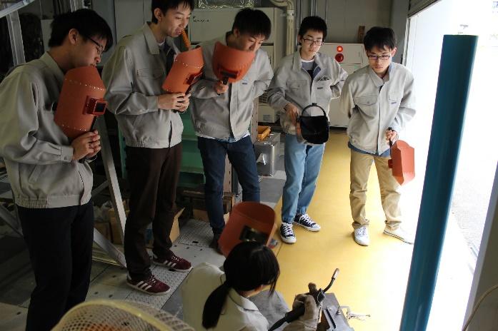 溶接機械の説明を受ける学生