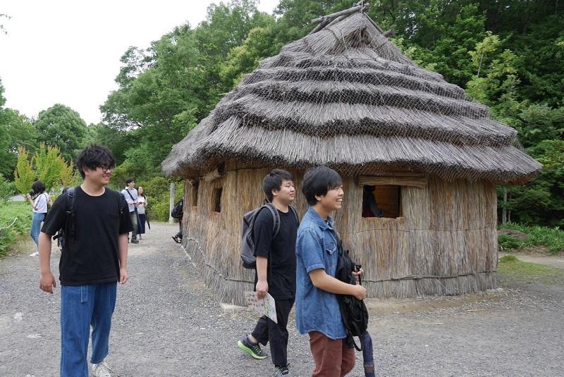 アイヌの家屋を見学する学生