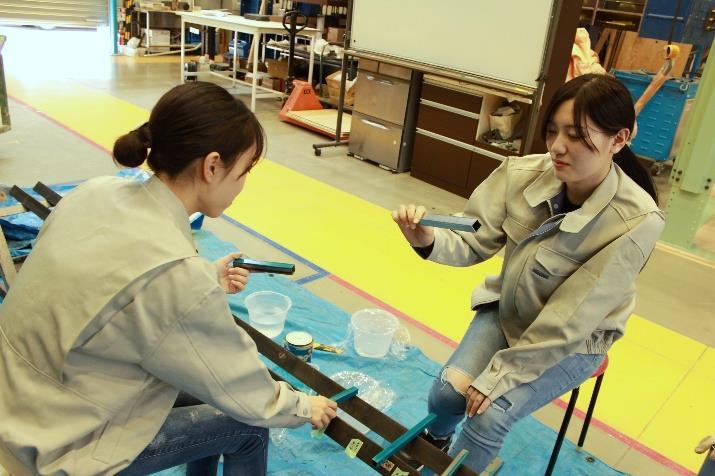 塗装後の表面をチェックするメンバー