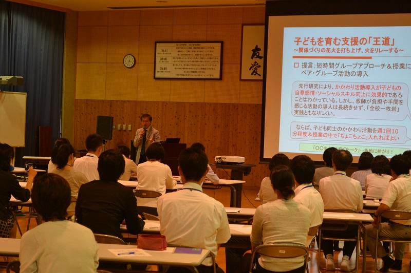 校内研修会；実施責任者（曽山）による全体講演の様子。かかわり活動の意義とそれを支えるカウンセリング理論について、参加学生、50名を超える教員が真摯に学んでいる。