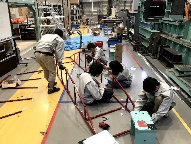 塗装が完了し完成に向けて橋を組み立てるメンバー