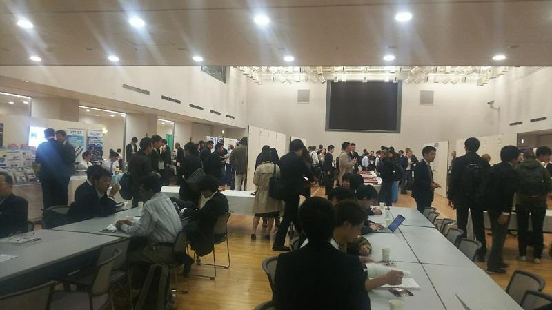 交流ホールで多くの参加者が議論・歓談を行っている様子。