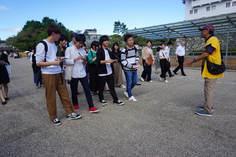 名古屋城でガイドの説明を受ける学生たち