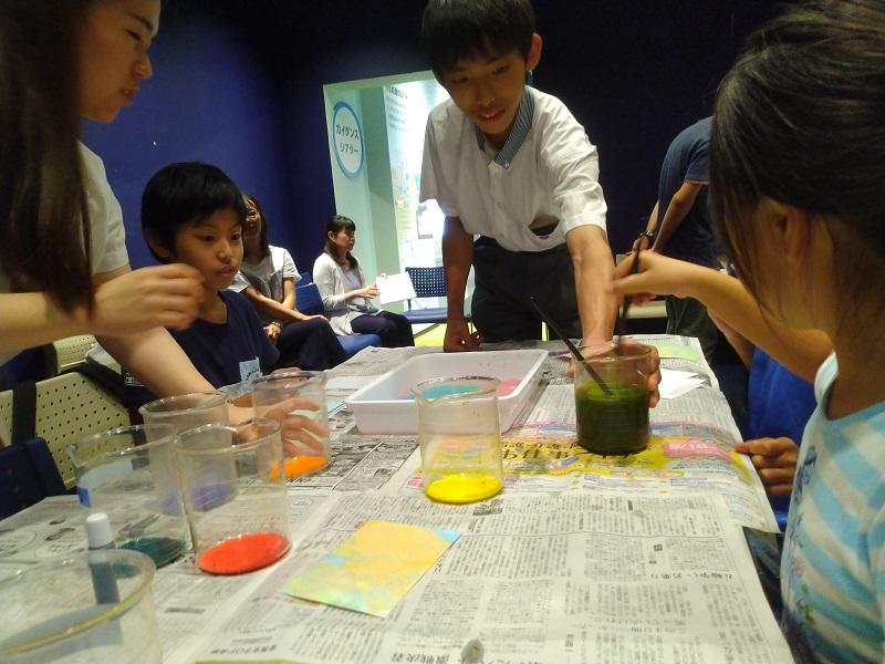 マーブリングの実験を補助する高校生(写真奥)と大学生(写真左)。
