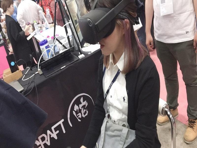 VRを用いたシューティングゲームを体験している様子。ゲームと同時に脳波が測定できるようになっており、集中すると後ろの画面の立方体の色が変わるそうです。
