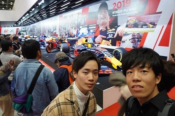 ホンダF1マシンの前にて：ホンダが今年からエンジンを提供しているF1マシンを間近で見ることができた。この距離でF1マシンを見る機会はなかなかないため貴重な経験となった。他にもアイルトン・セナの乗っていたマシンも展示されており、ホンダの歴史を感じた。