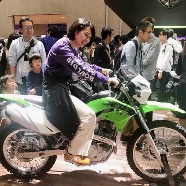 Kawasakiのブースで実際のバイクに乗っている様子。ほとんどのブースでこのように自動車が展示してあり、中に乗り込むこともできました。