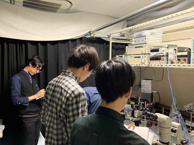 励起用レーザーを試料に照射するためにミラーの位置を調節しているのを見学している写真。
