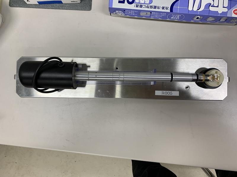 強化2軸ホルダーの写真であり、先端部に薄片化加工された試料を設置し、収差補正透過型電子顕微鏡R005に挿入することで試料の高分解能観察を行った。