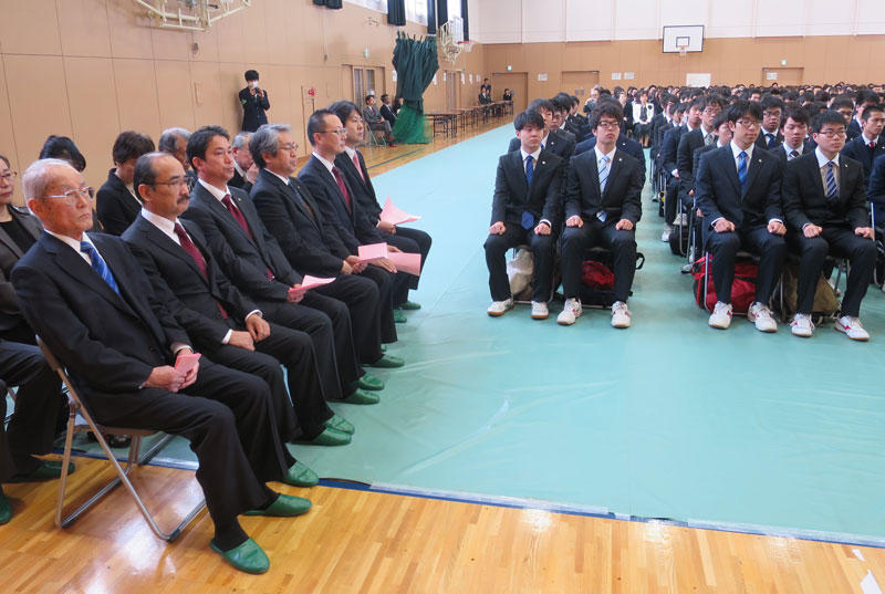 入学式に臨む小笠原日出男理事長ら（左側）と新入生（右側）