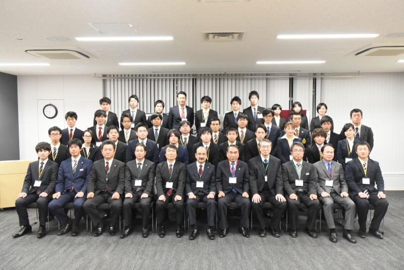 集合写真に臨む山田会長(最前列右から5番目)と交付を受けた学生ら