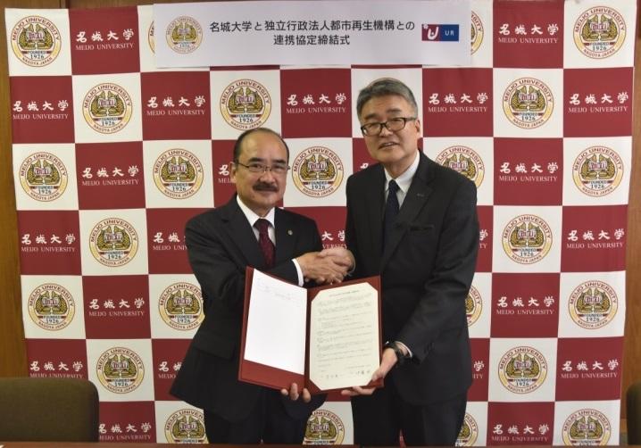協定を締結し握手する吉久学長(左)と伊藤支社長