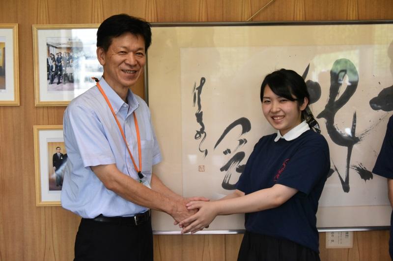 区長と握手する酒井さん
