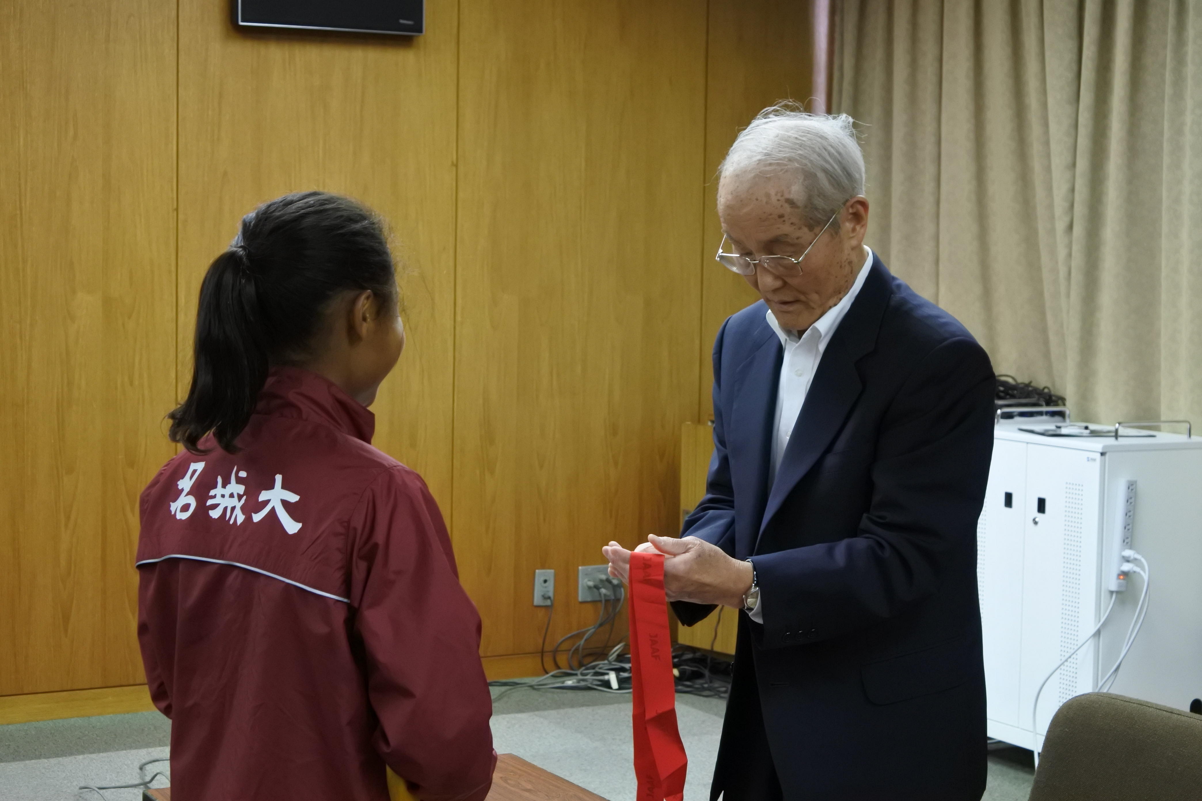 獲得したメダルを手に取る小笠原理事長