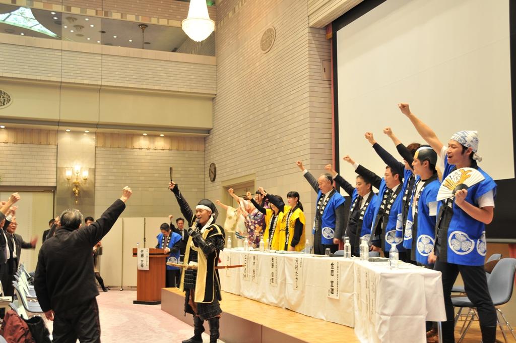 名古屋城前の集客施設が「金シャチ横丁」に決まり、名古屋おもてなし武将隊の音頭で勝ち鬨をあげる参加者たち
