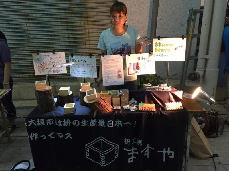 星空カフェで升のピアスとイヤリングを売る秋山さん＝2015年7月、岐阜市の柳ケ瀬で