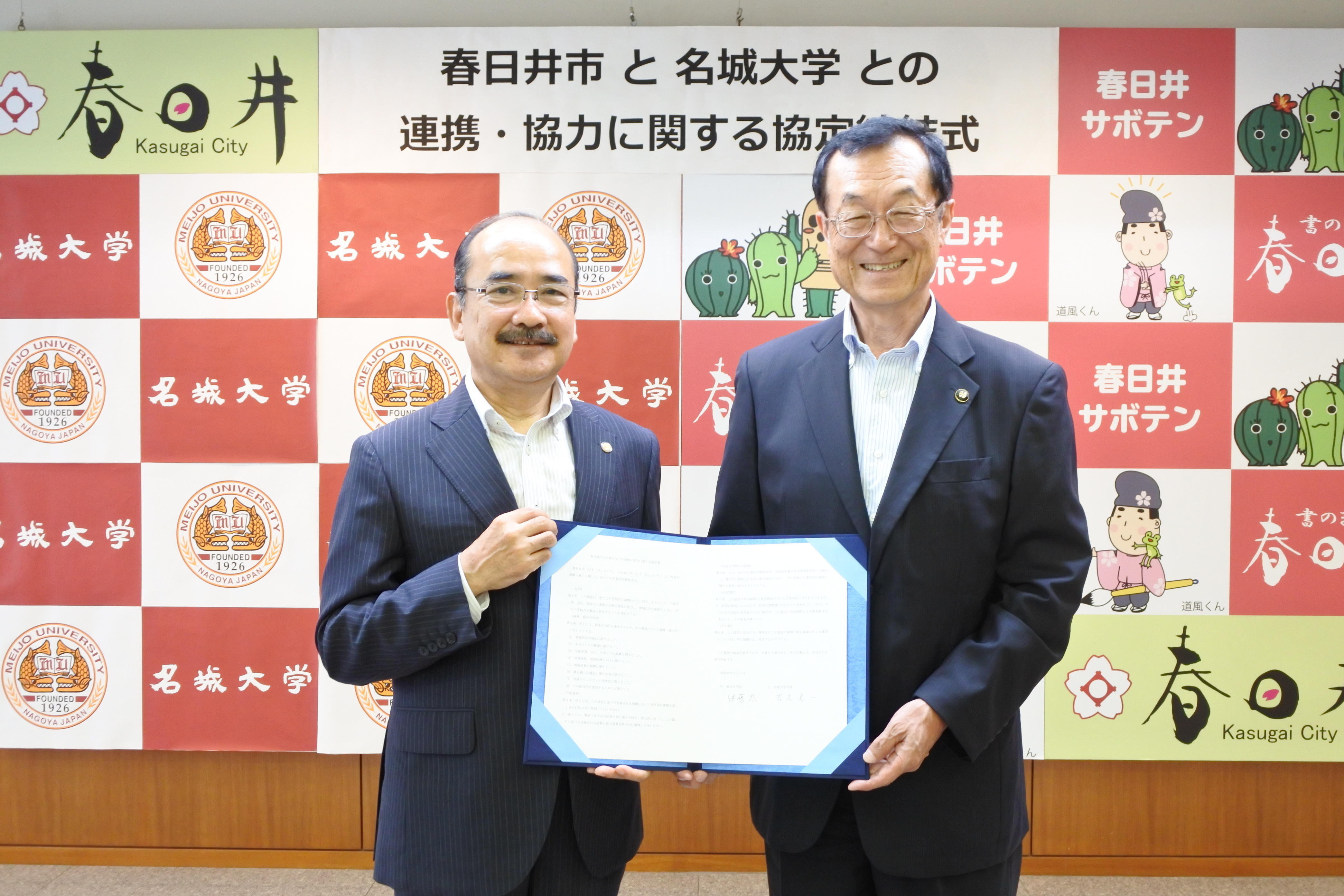 協定書を手にする吉久光一学長（左）と伊藤太市長