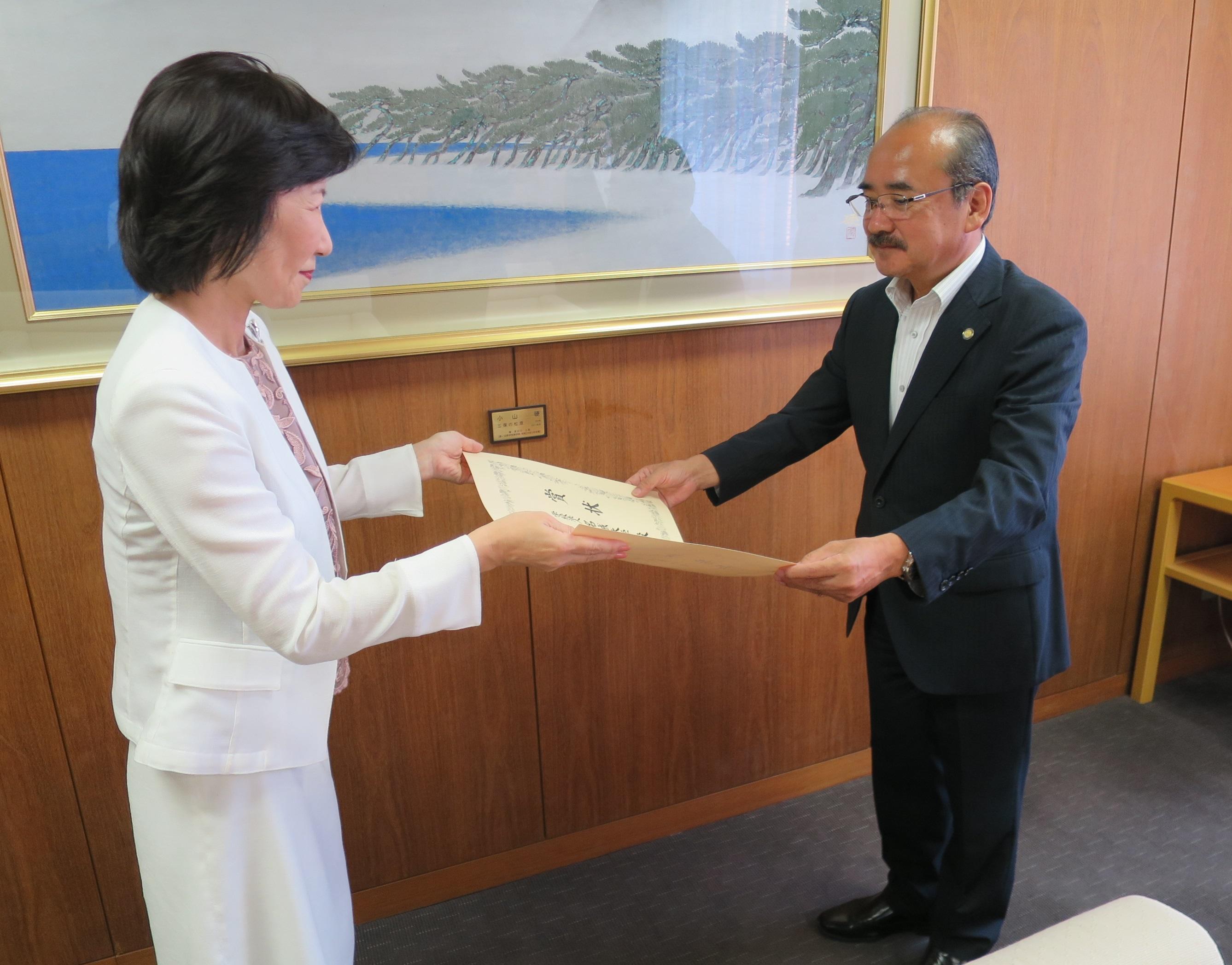 明石伸子理事長(左)から文部科学大臣賞の賞状を受け取る吉久光一学長