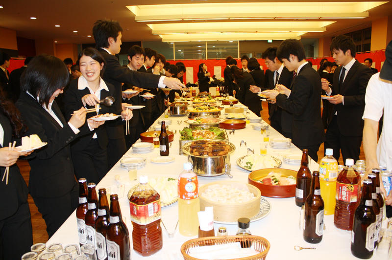 祝賀パーティーでさっそく料理にはしを伸ばす受賞者たち