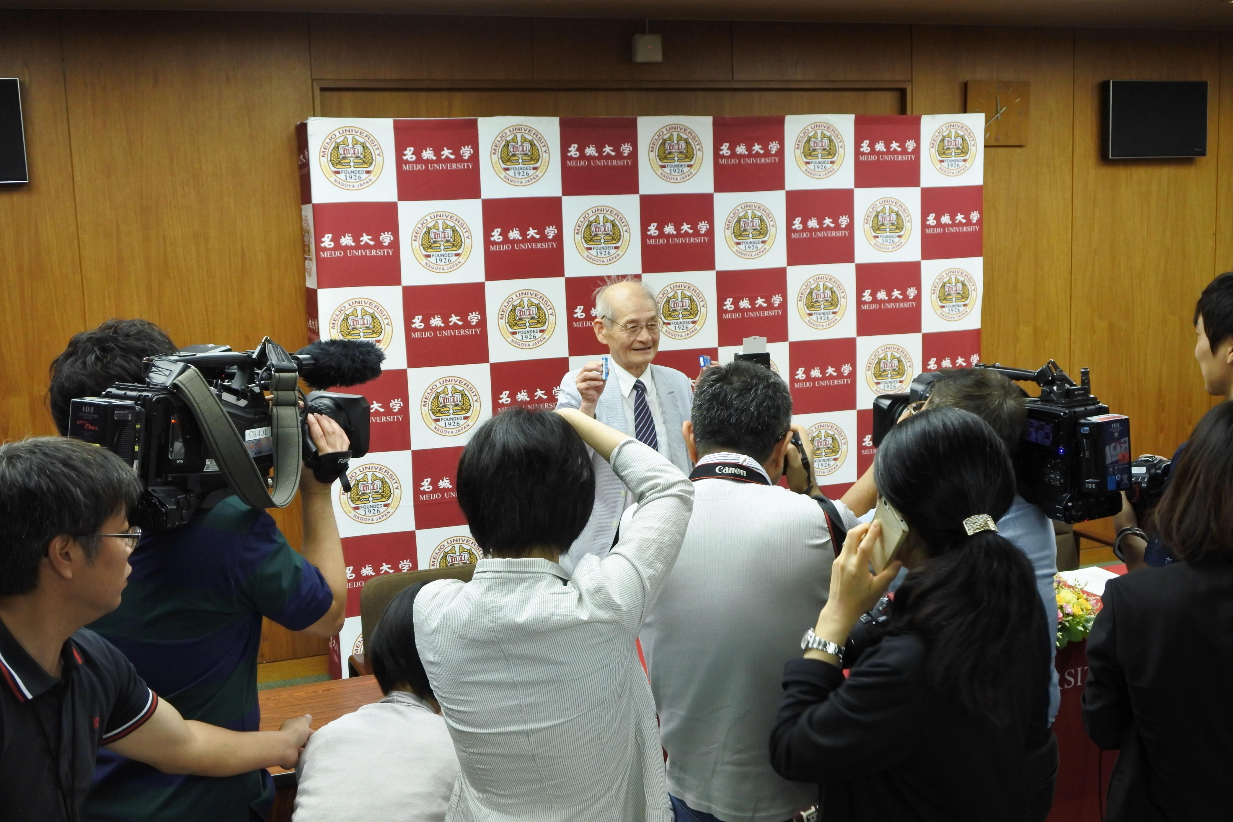 カメラの放列の前で写真撮影に応じる吉野彰教授