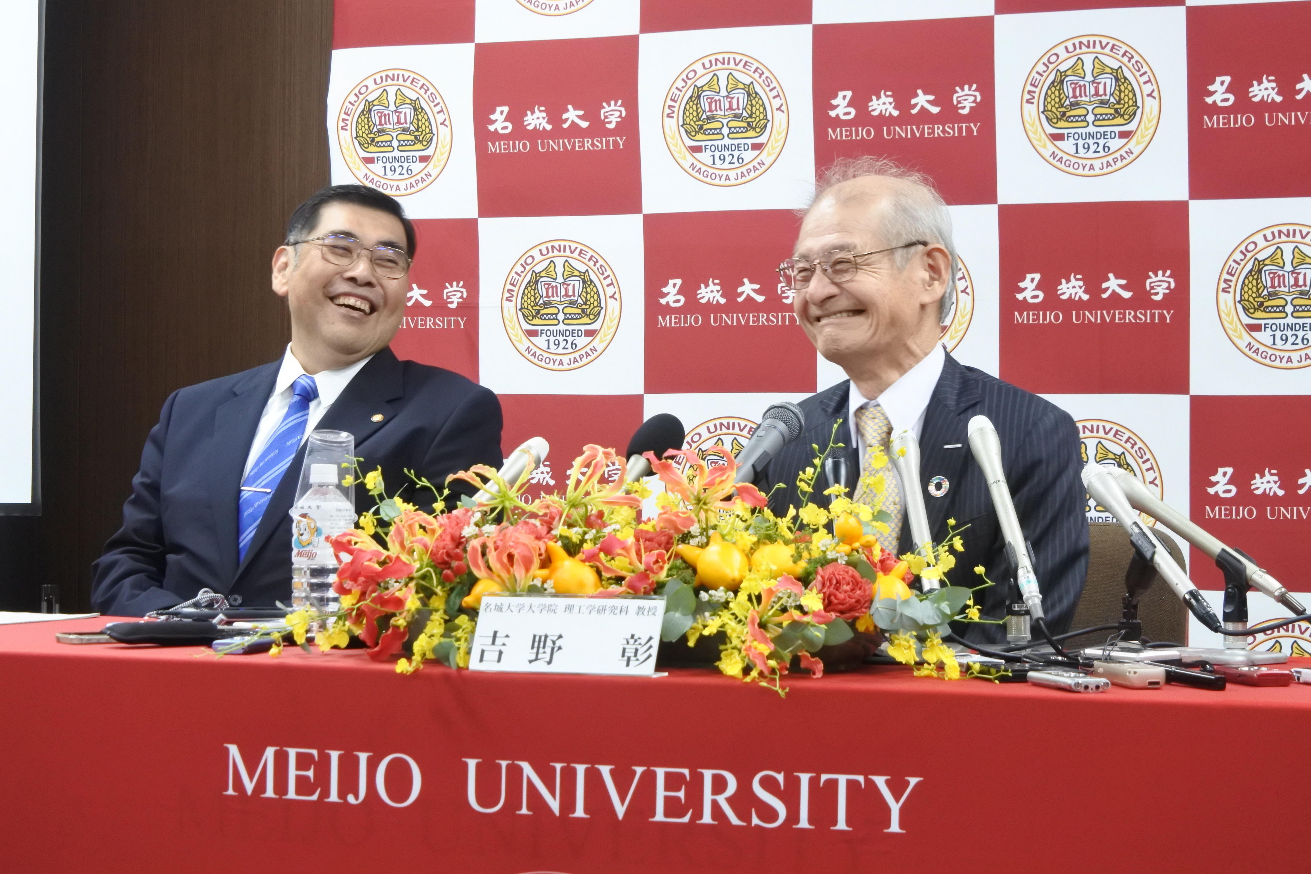 記者会見で笑顔を見せる吉野彰教授（右）と小原章裕学長