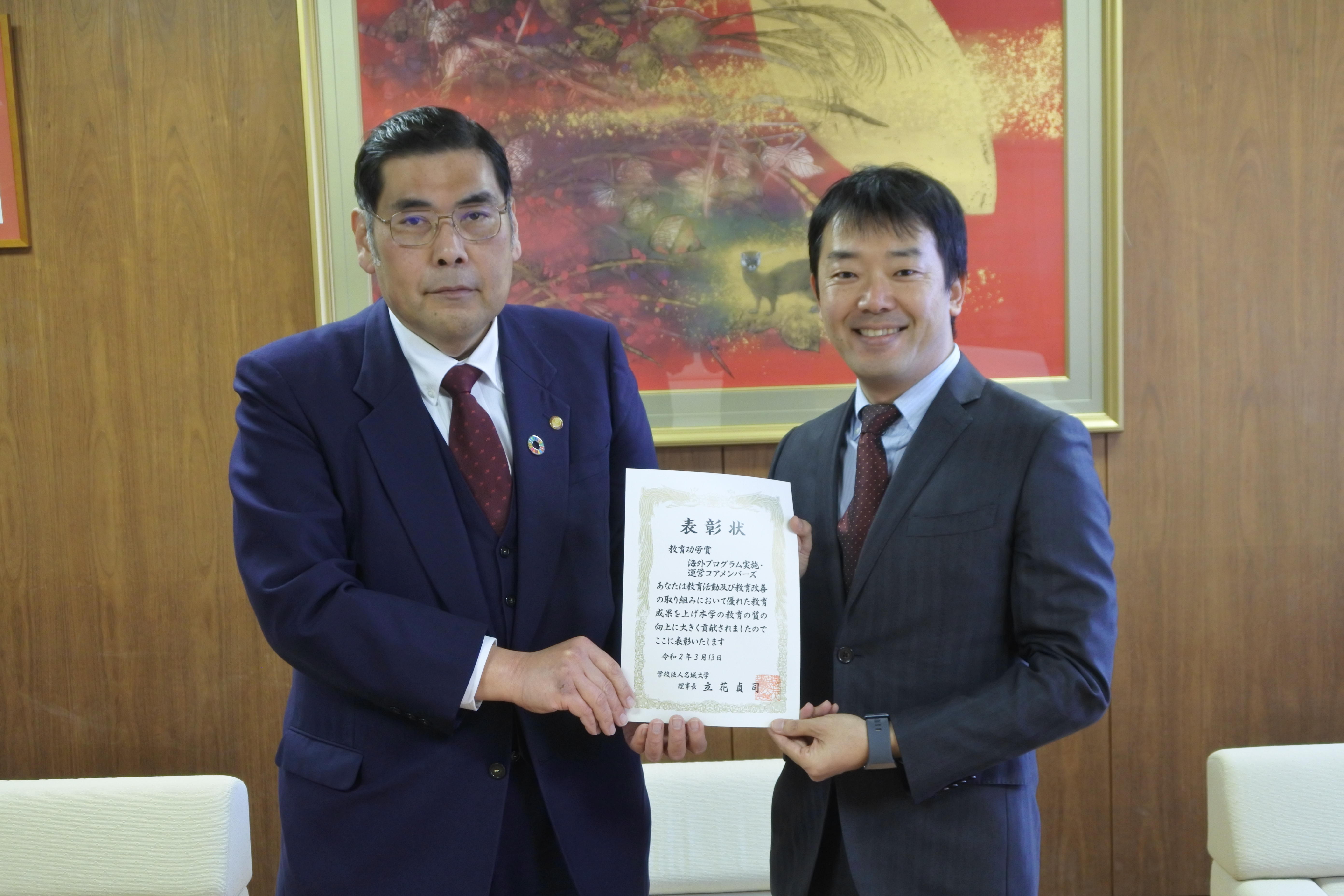 小原章裕学長(左)から表彰状を受け取った津村文彦教授
