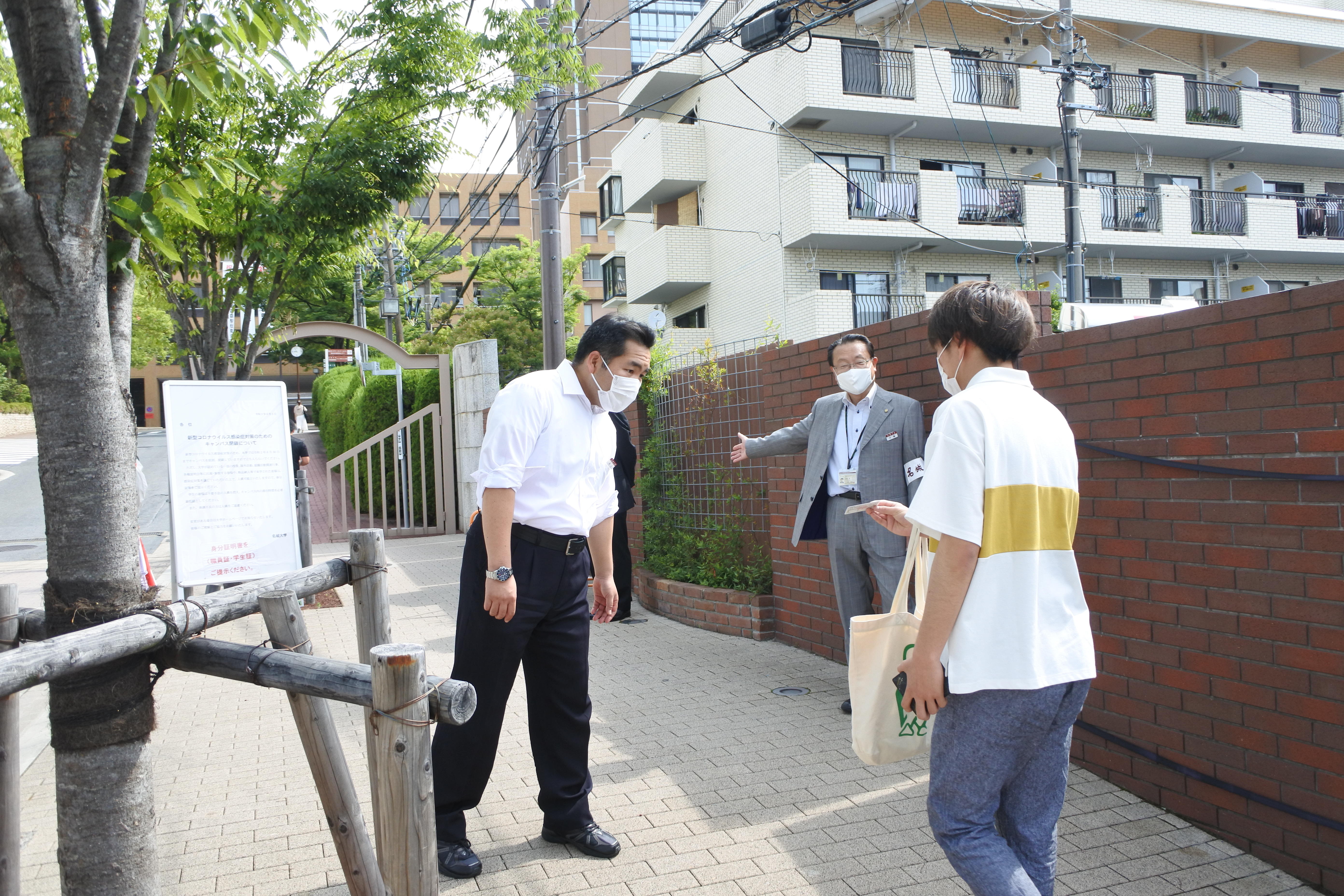 午前9時ごろ、正門前で学生証をチェックする職員