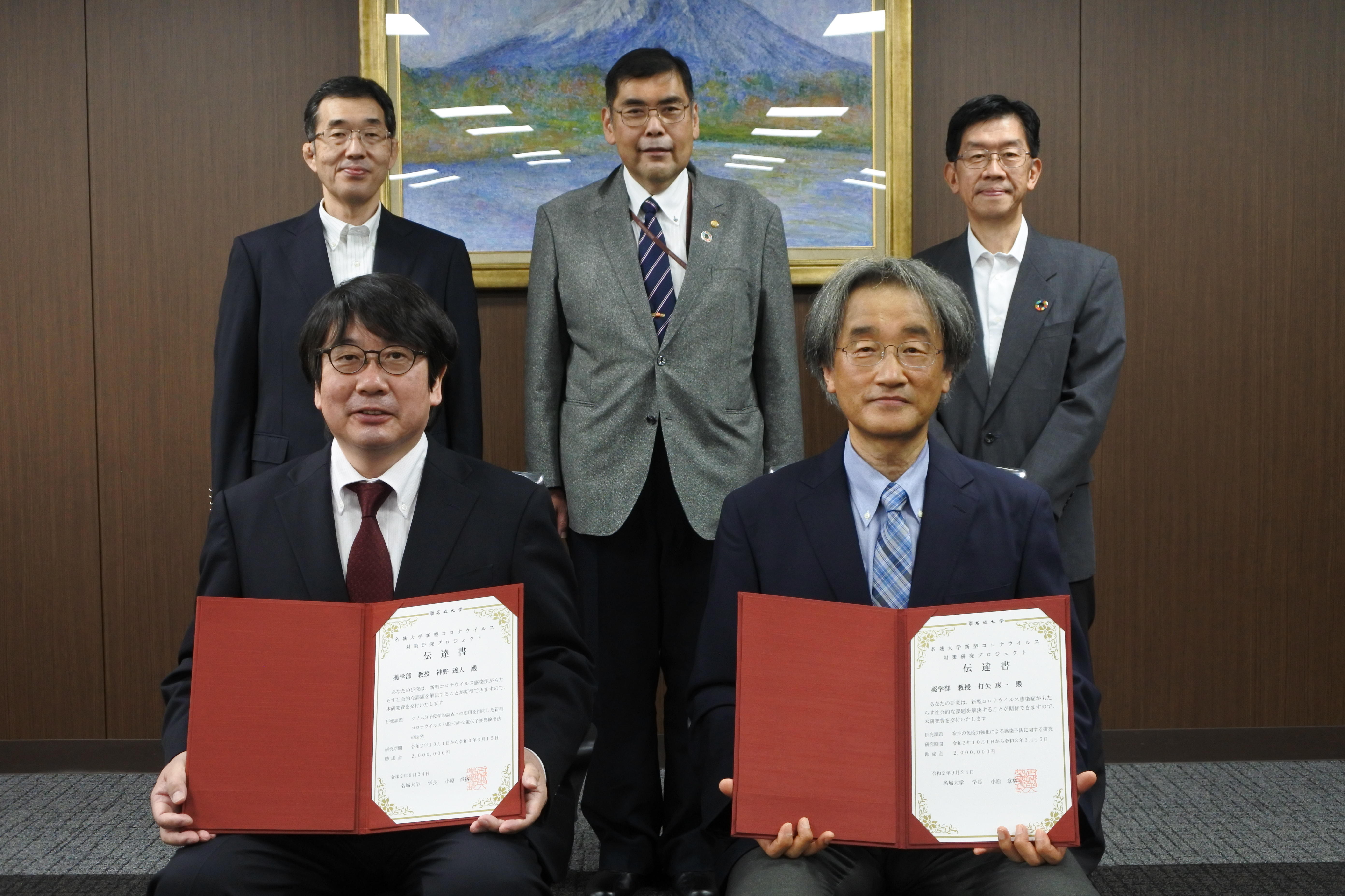 伝達書を受け取った（前列左から）神野透人教授、打矢惠一教授,（後列左から）小髙猛司学術研究支援センター長、小原章裕学長、平松正行副学長