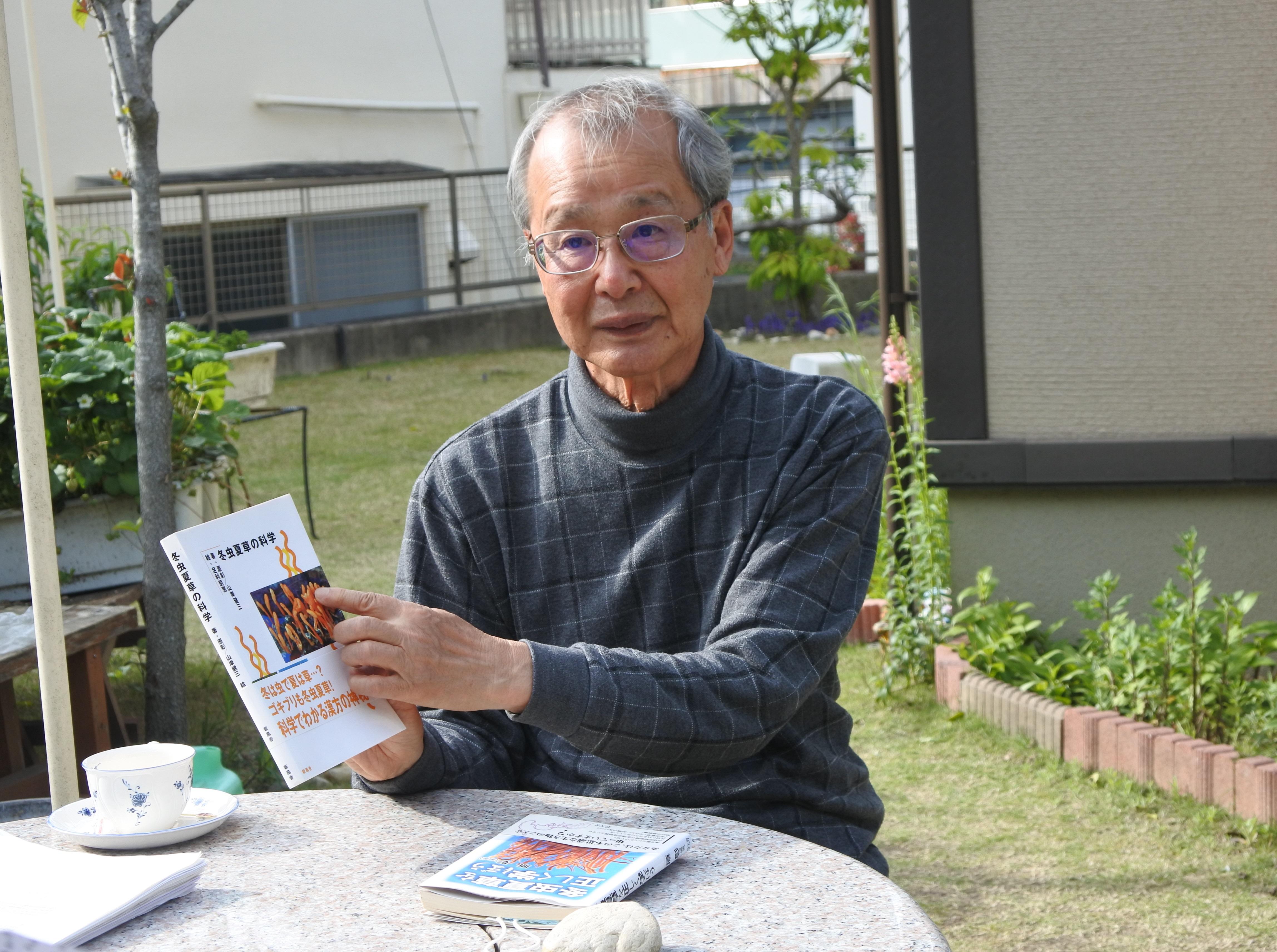 冬虫夏草に関する著書を手にする原彰名誉教授