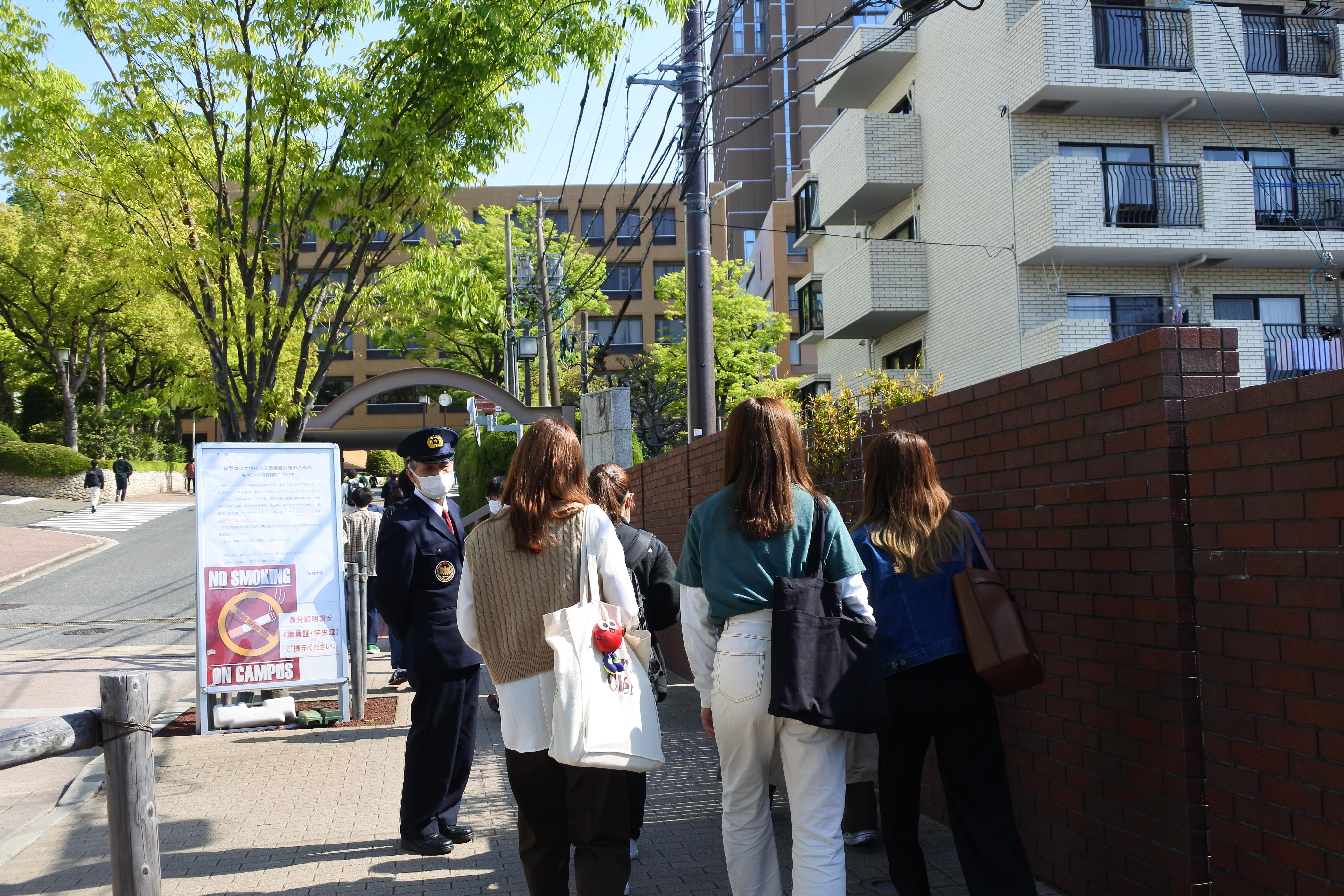 学生証を提示して天白キャンパスに入る学生たち