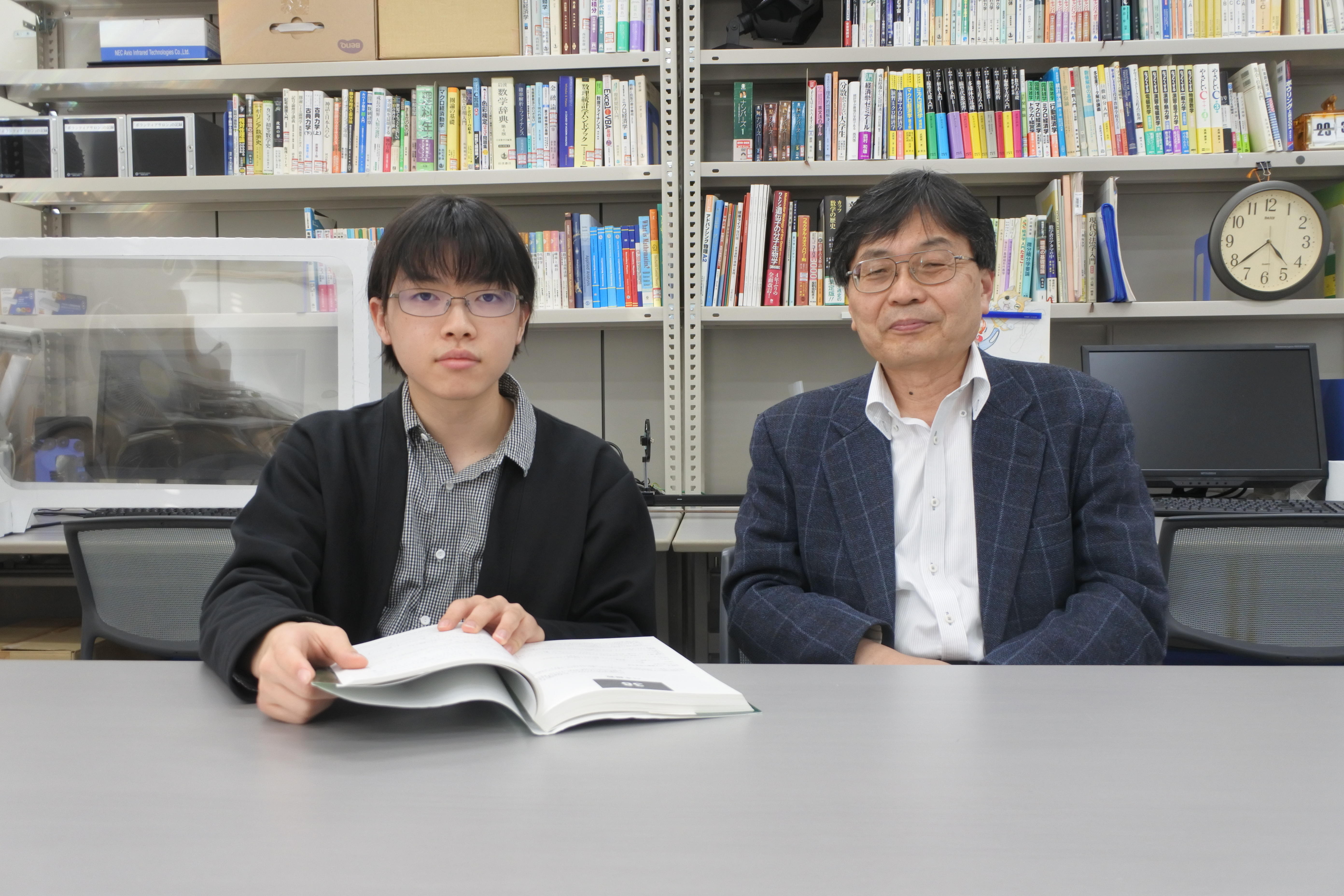 鈴木紀明教授（右）とその著書を開く大岩亮太さん