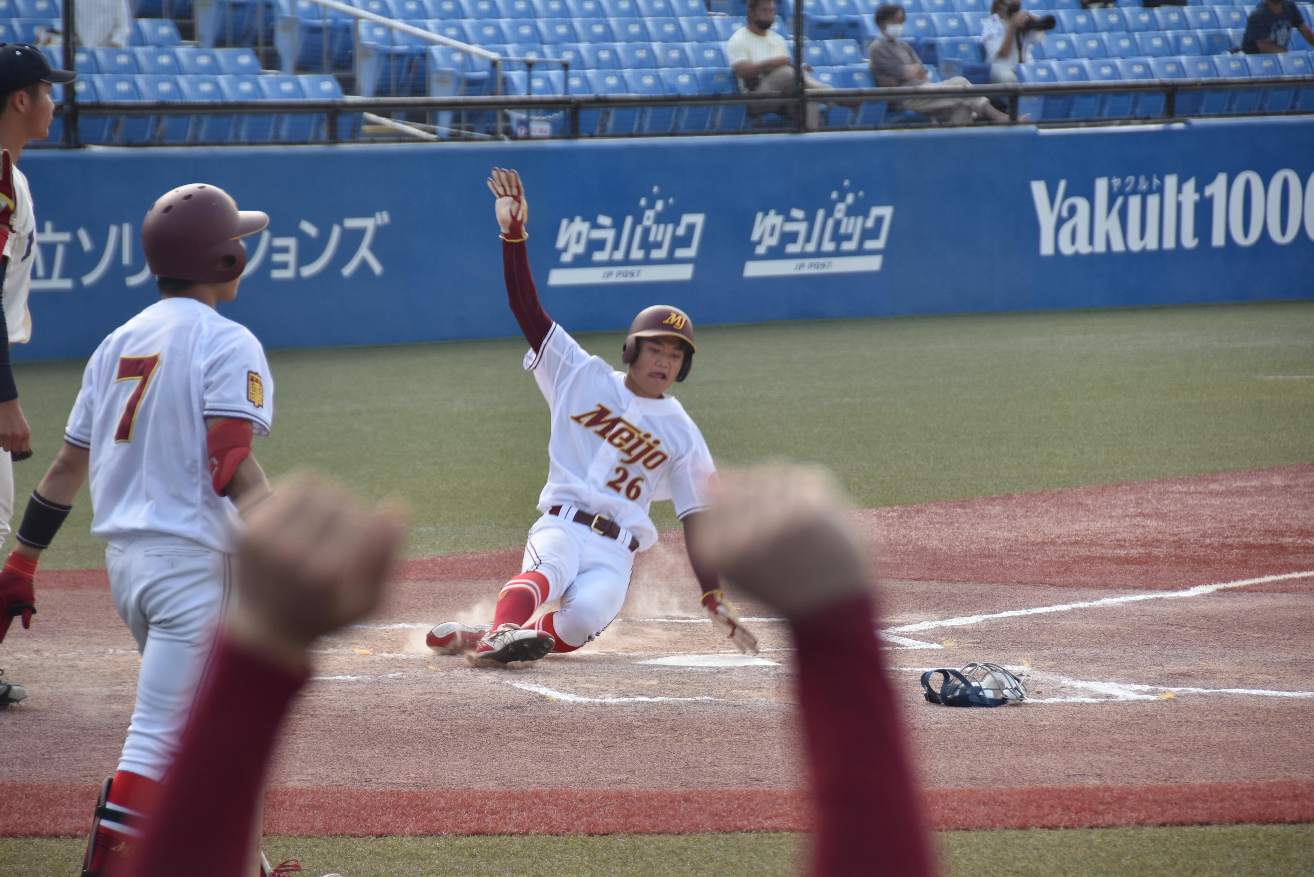 中盤の追い上げ。六回、野口泰司選手（経済学部3年）の適時打で多和田尚旗選手（経営学部1年）（26番）が生還。6点目=東京の神宮球場で