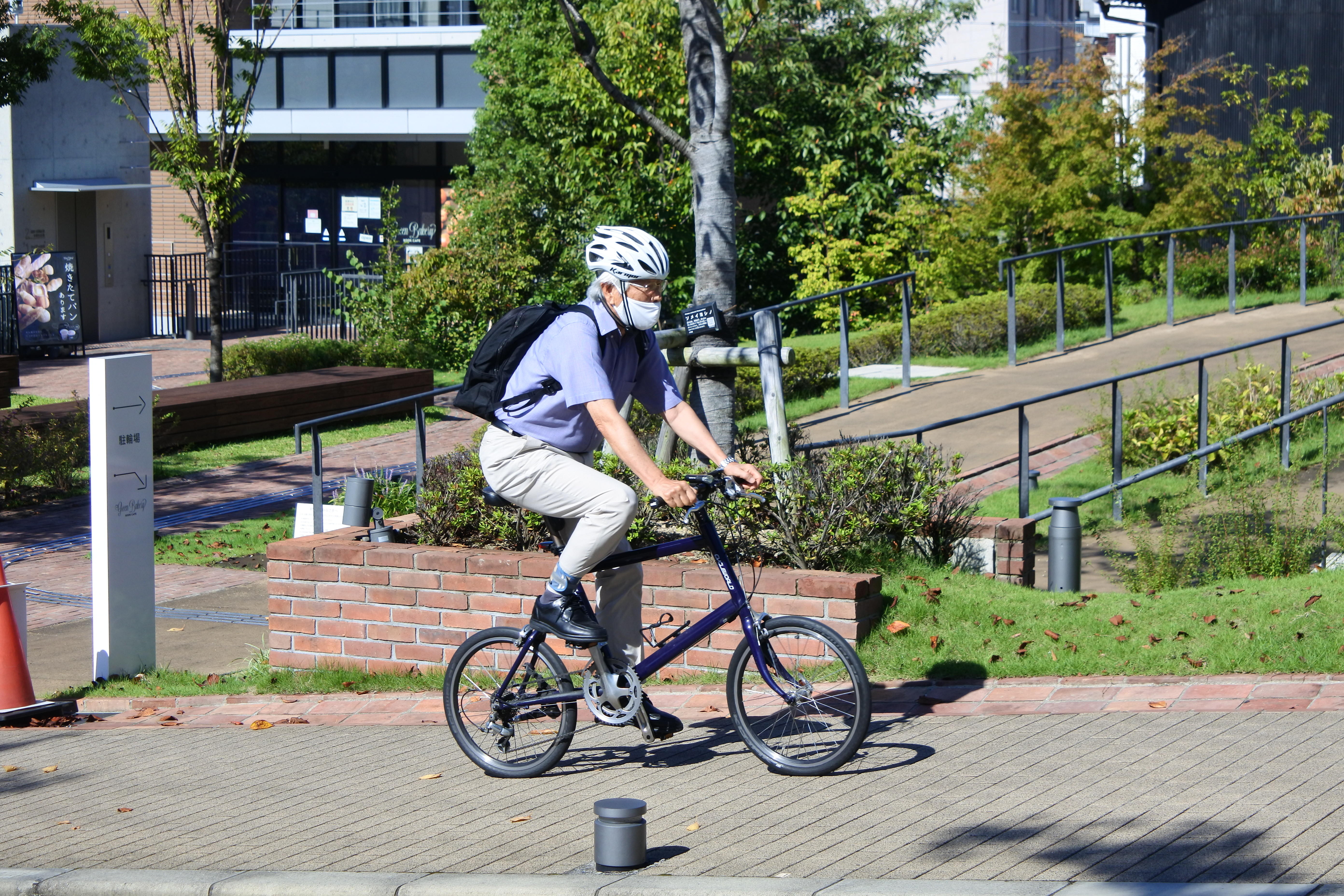 秋晴れの下、自転車で通勤する飯島澄男終身教授