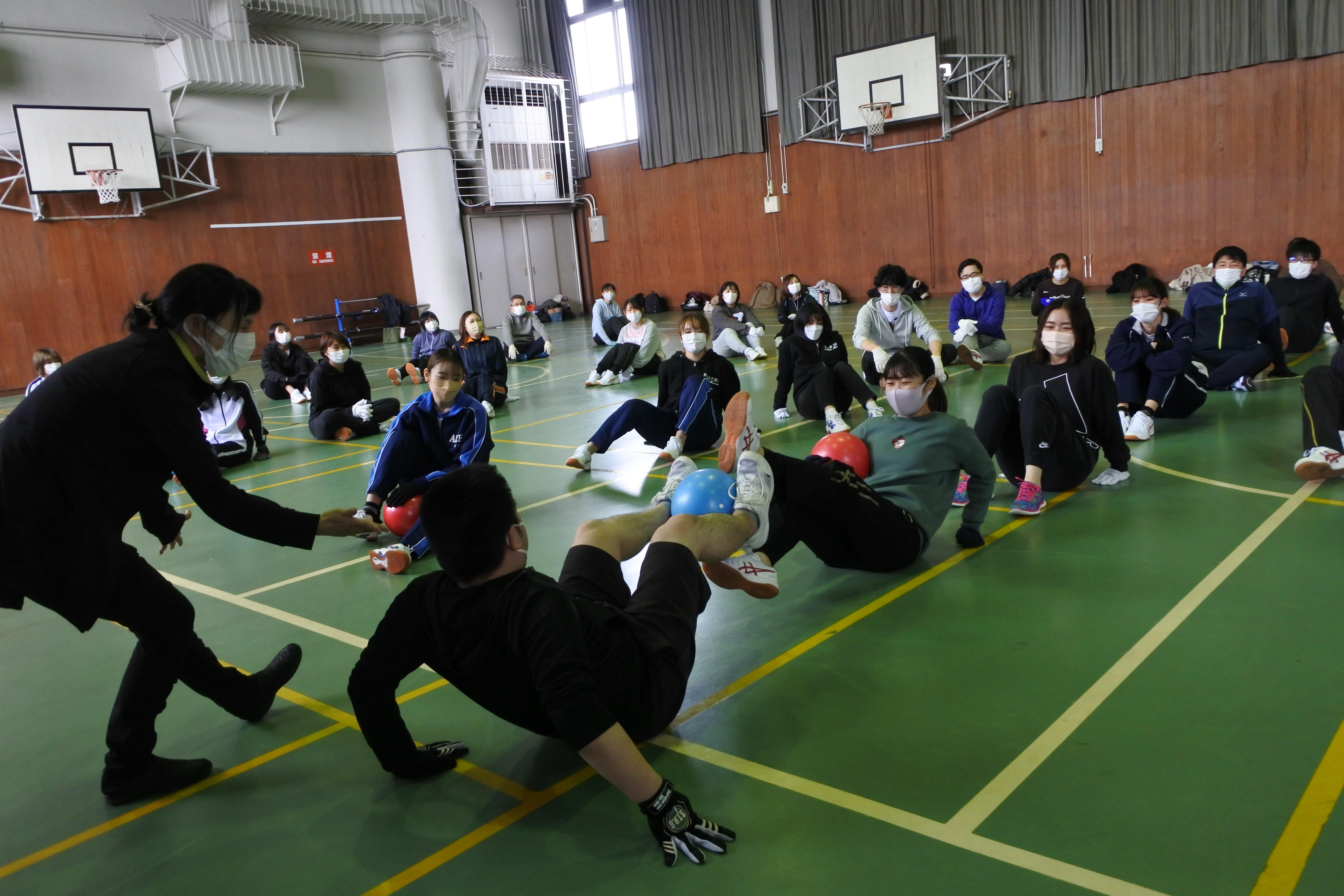 ボールを使った手軽な健康運動を教わる薬学部生ら(左は伊藤由美子日本体育大学准教授）