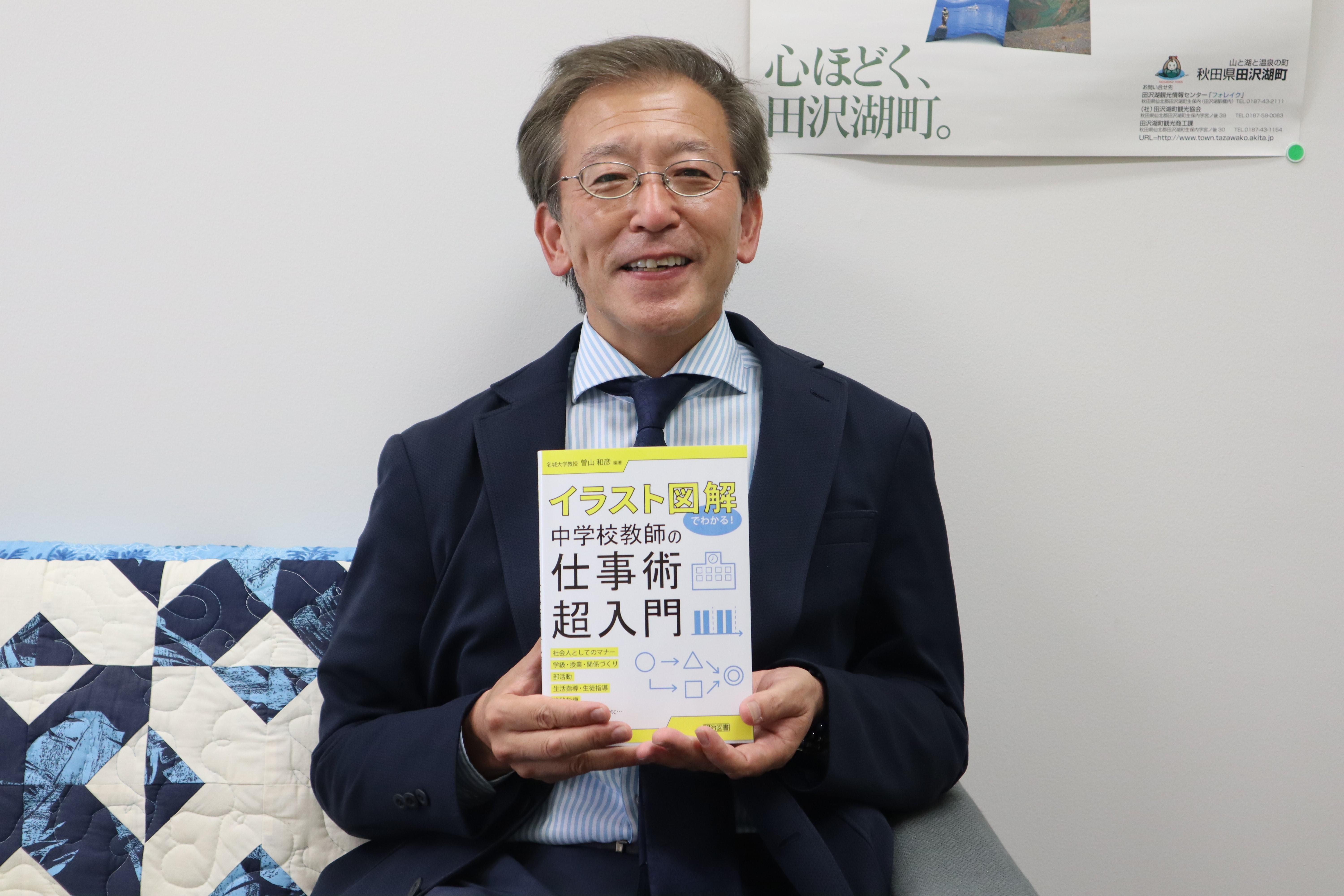 天白キャンパスの研究室で新刊を手にする曽山和彦教授