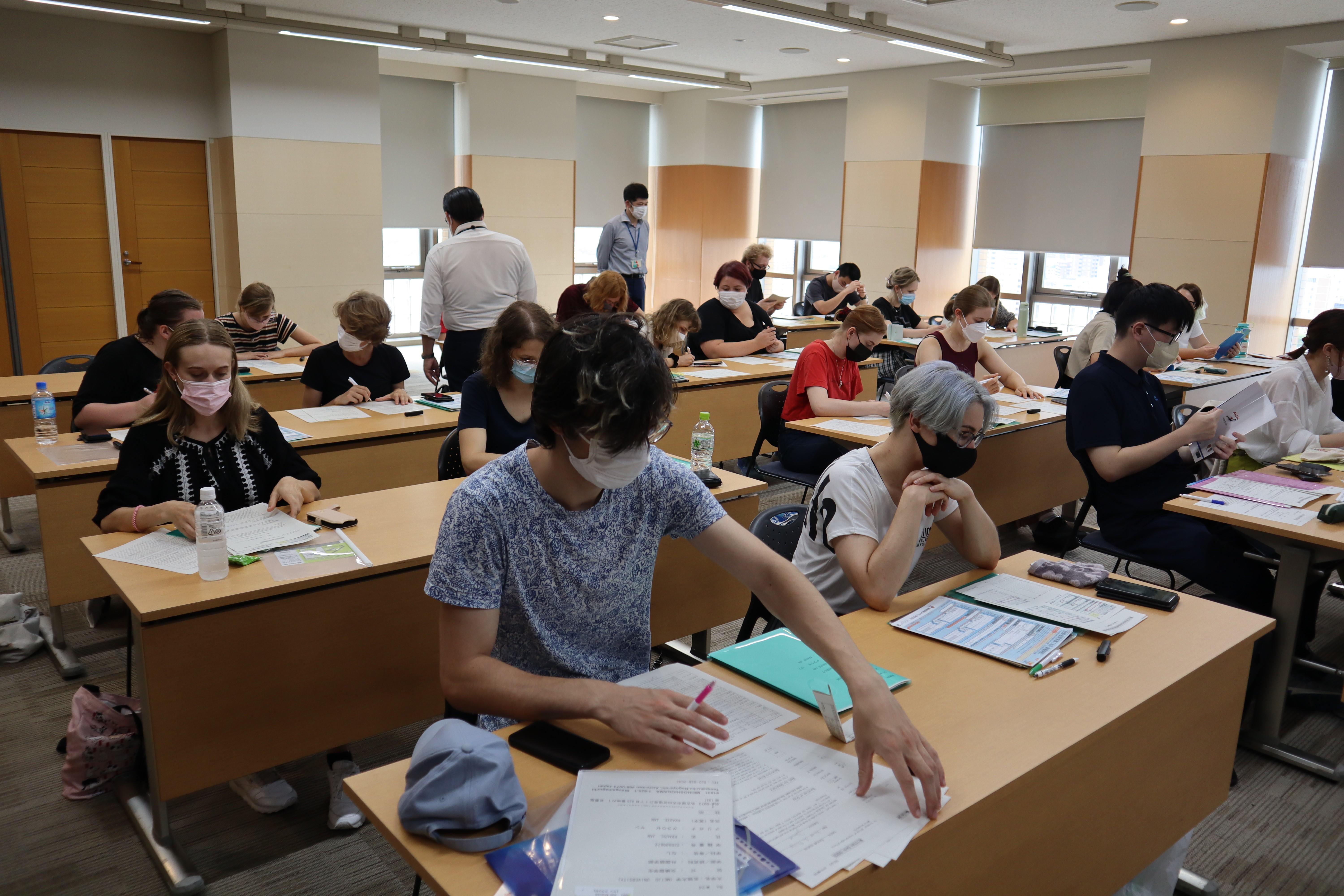 各種書類を日本語で記入する留学生