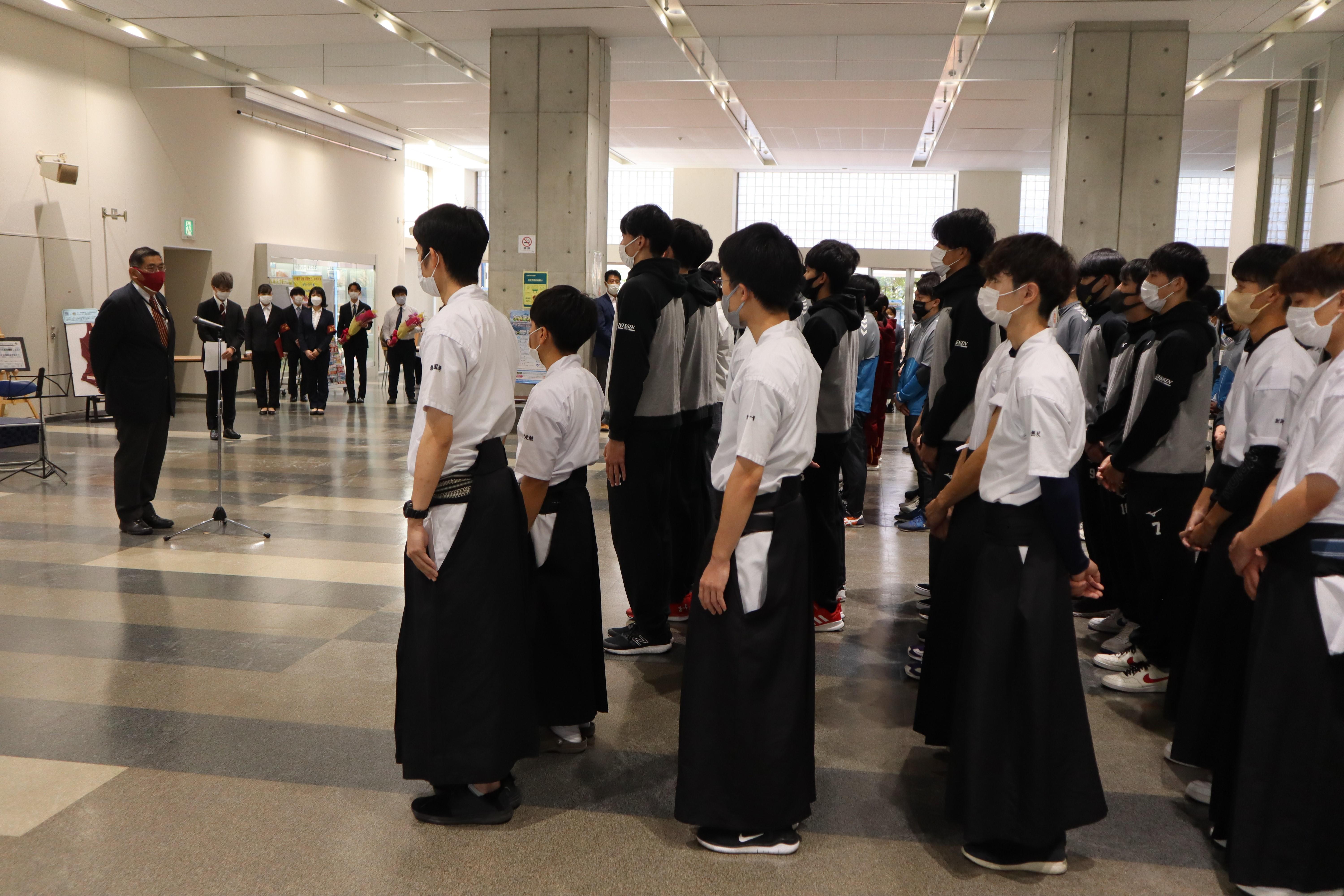 選手を激励する小原学長（左）