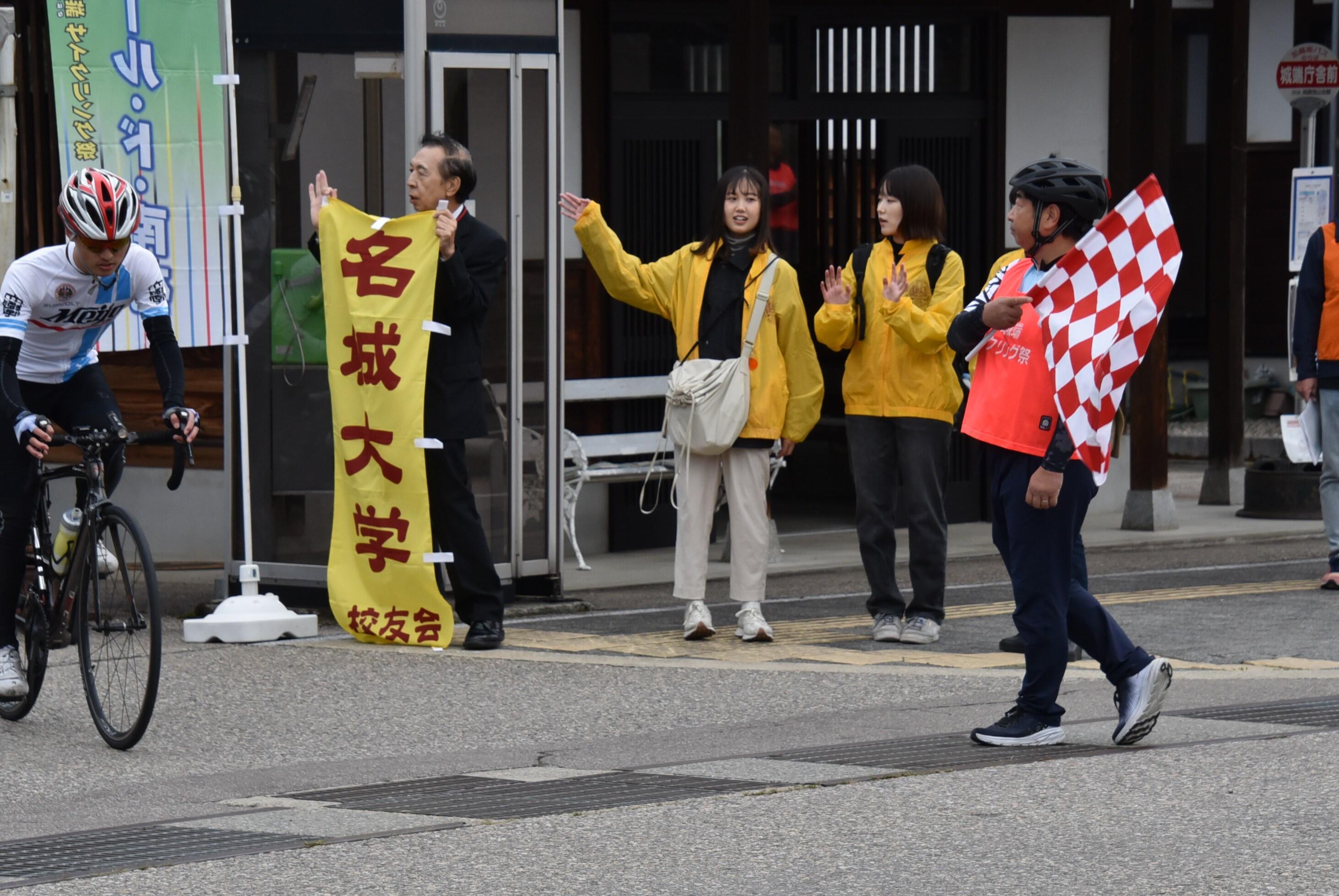 校友会の旗を持って激励する吉村支部長