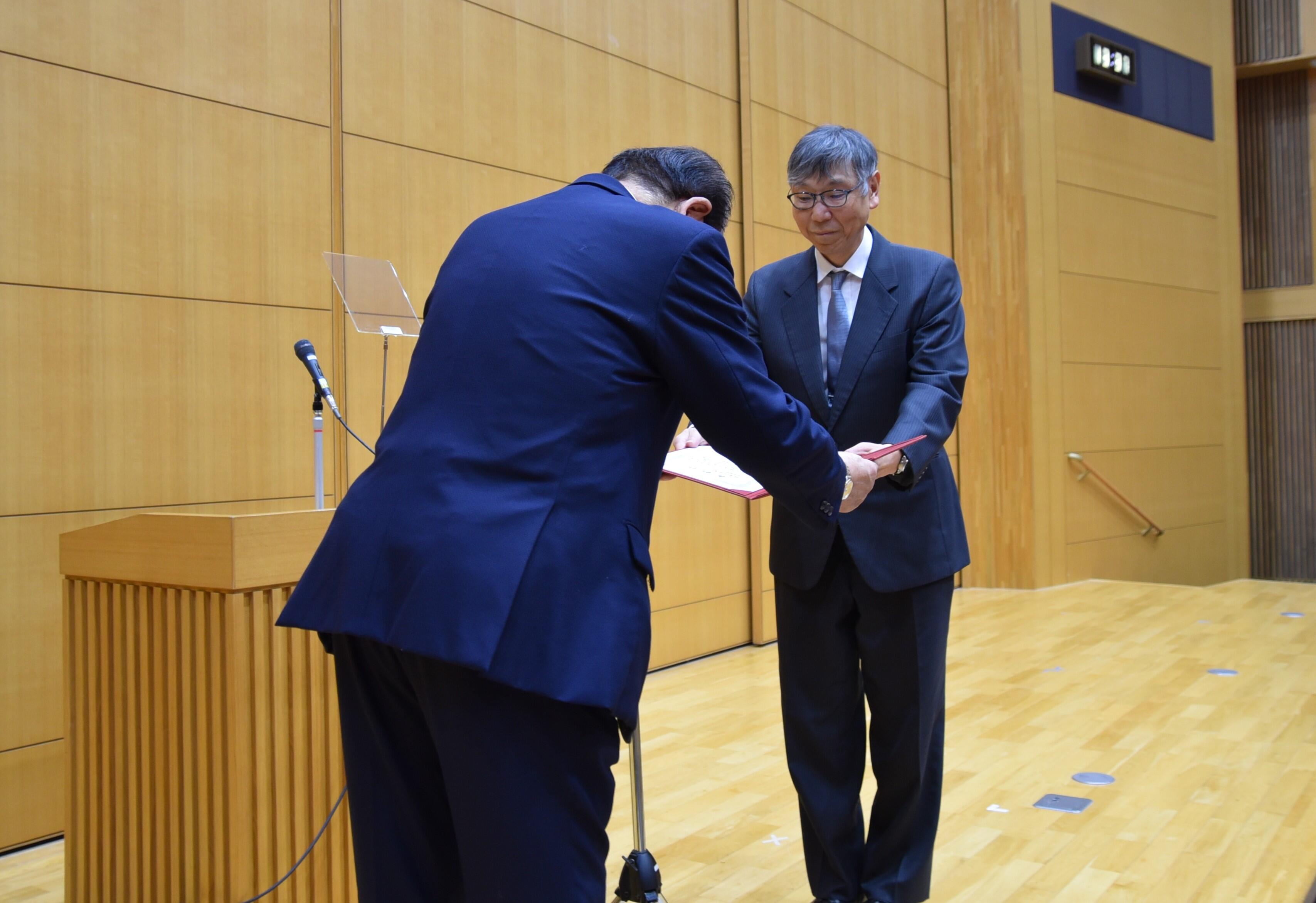 立花理事長から表彰状を渡される山本教授（右）