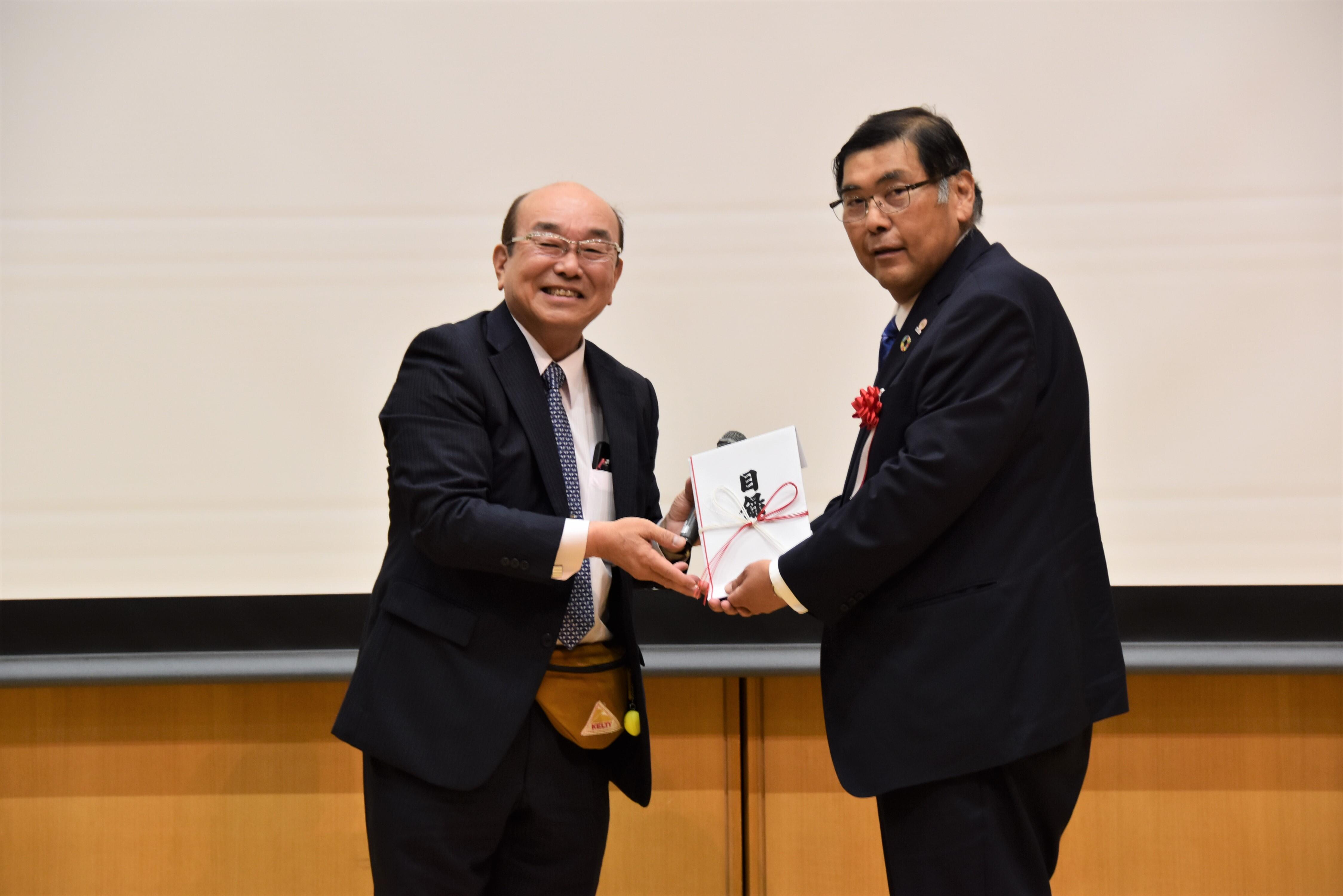目録を贈呈した常田会長（左）と小原専務理事