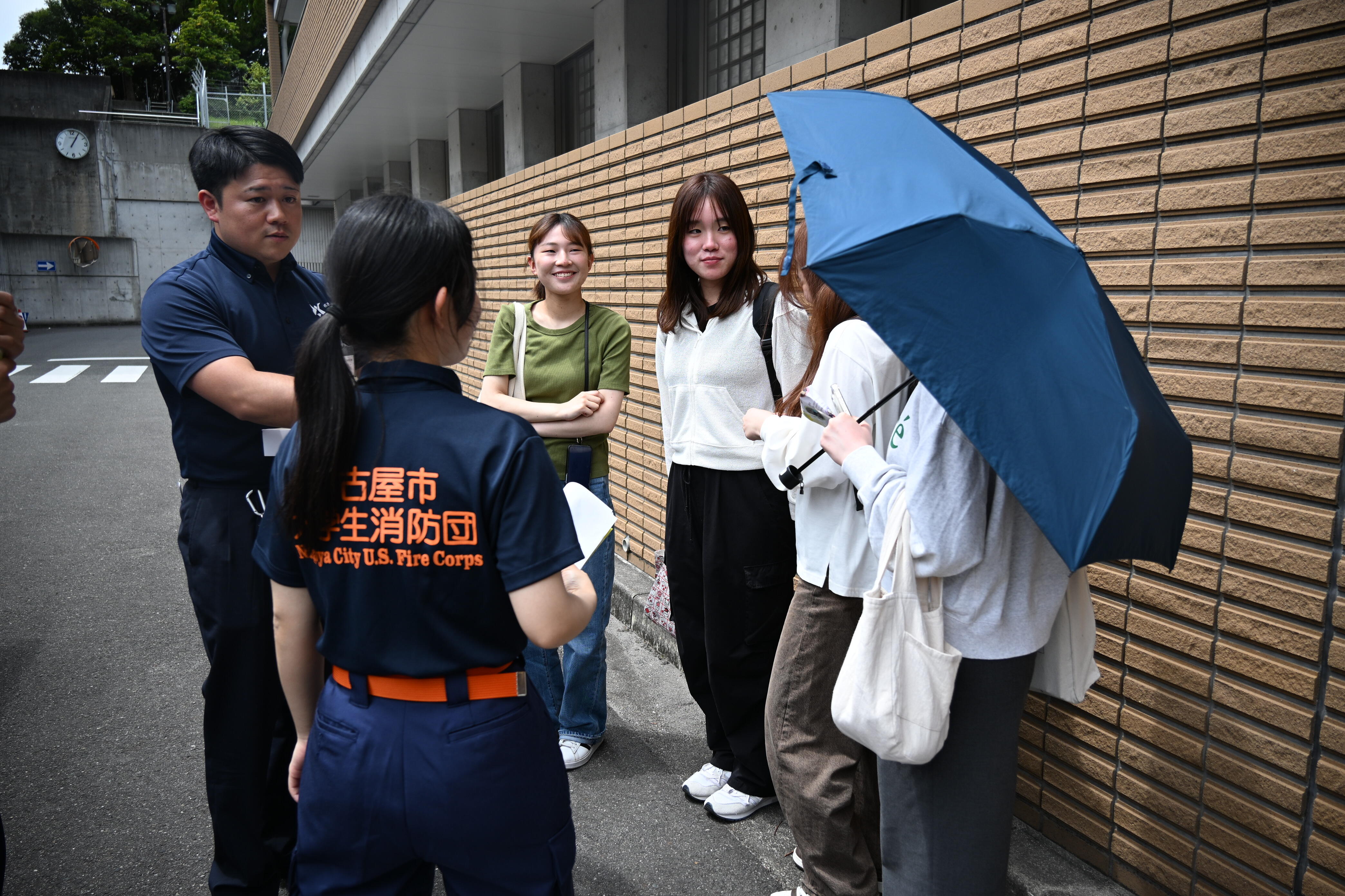 学生消防団について説明する団長の山下さん（左手前）