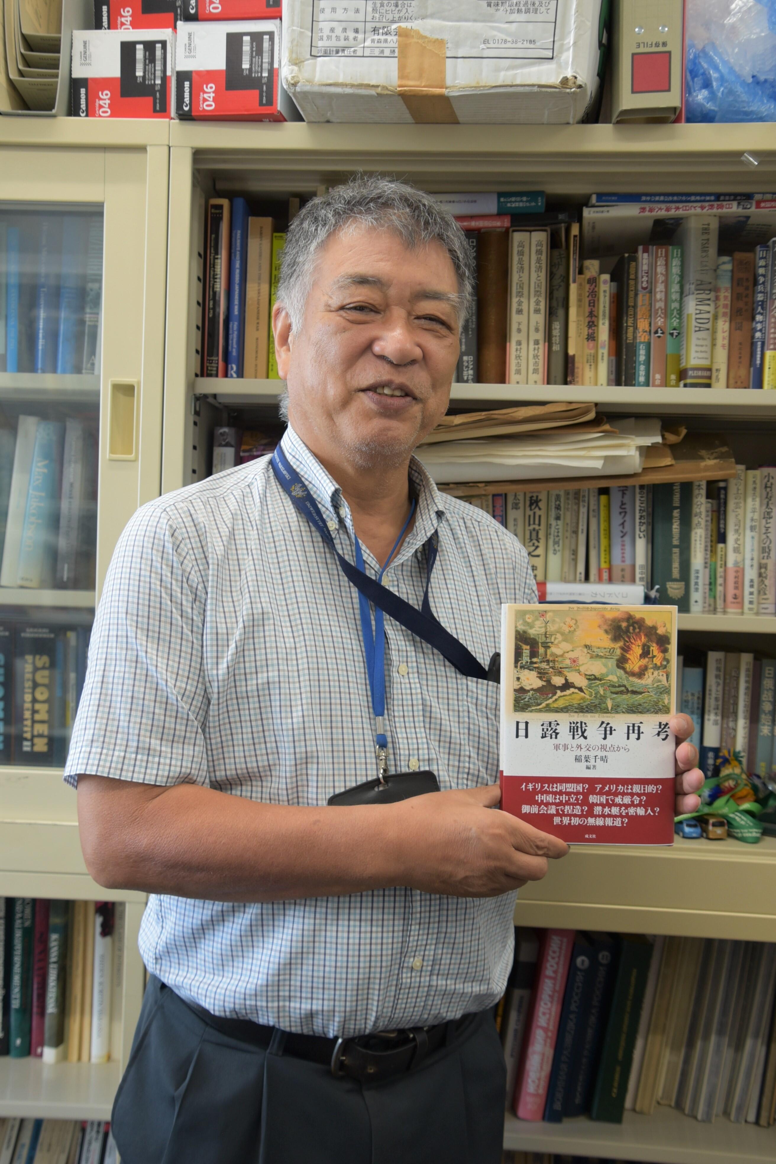　　　　　　　出版した編著書を手にする稲葉教授
