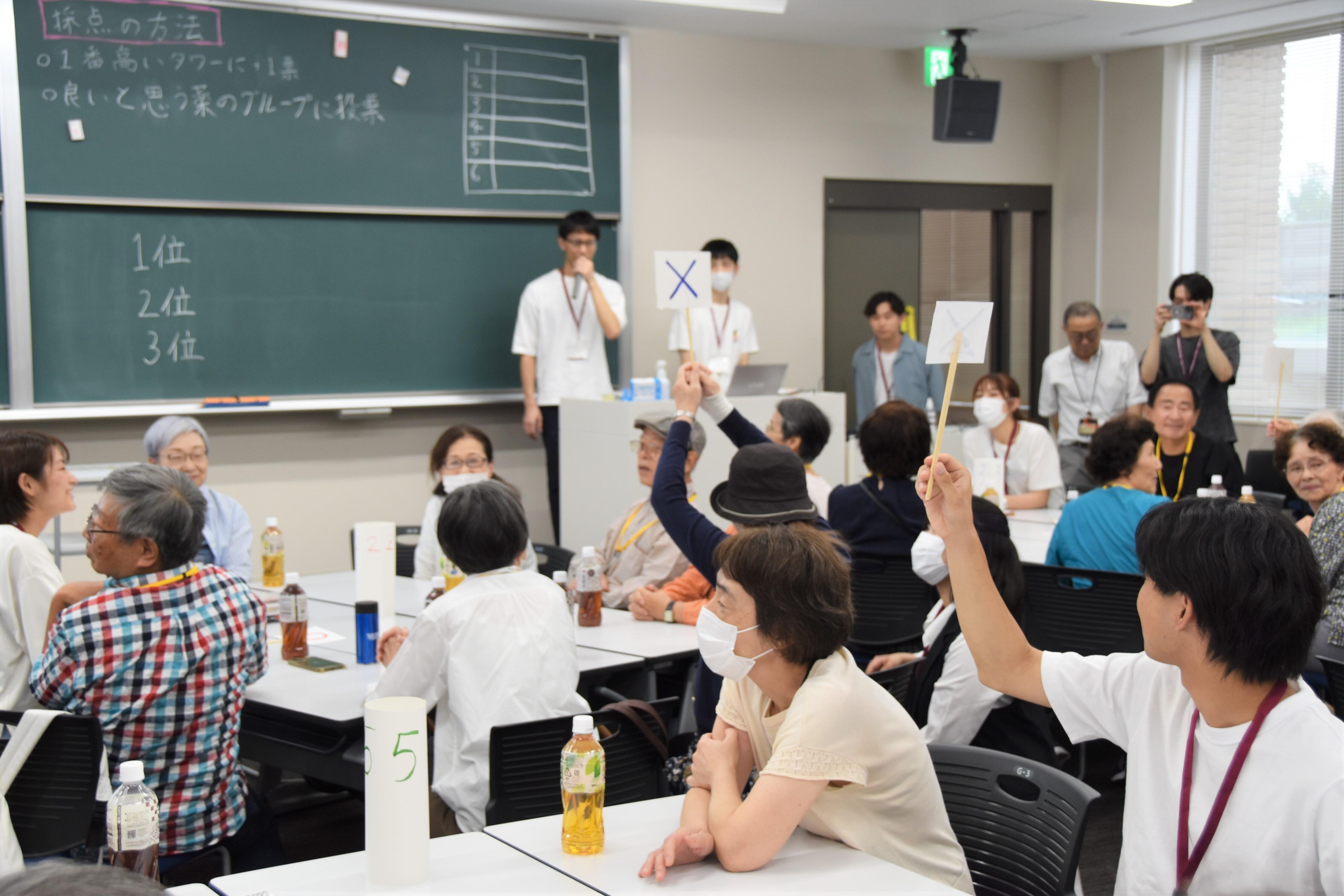 薬に関するクイズで○×の札を掲げる参加者