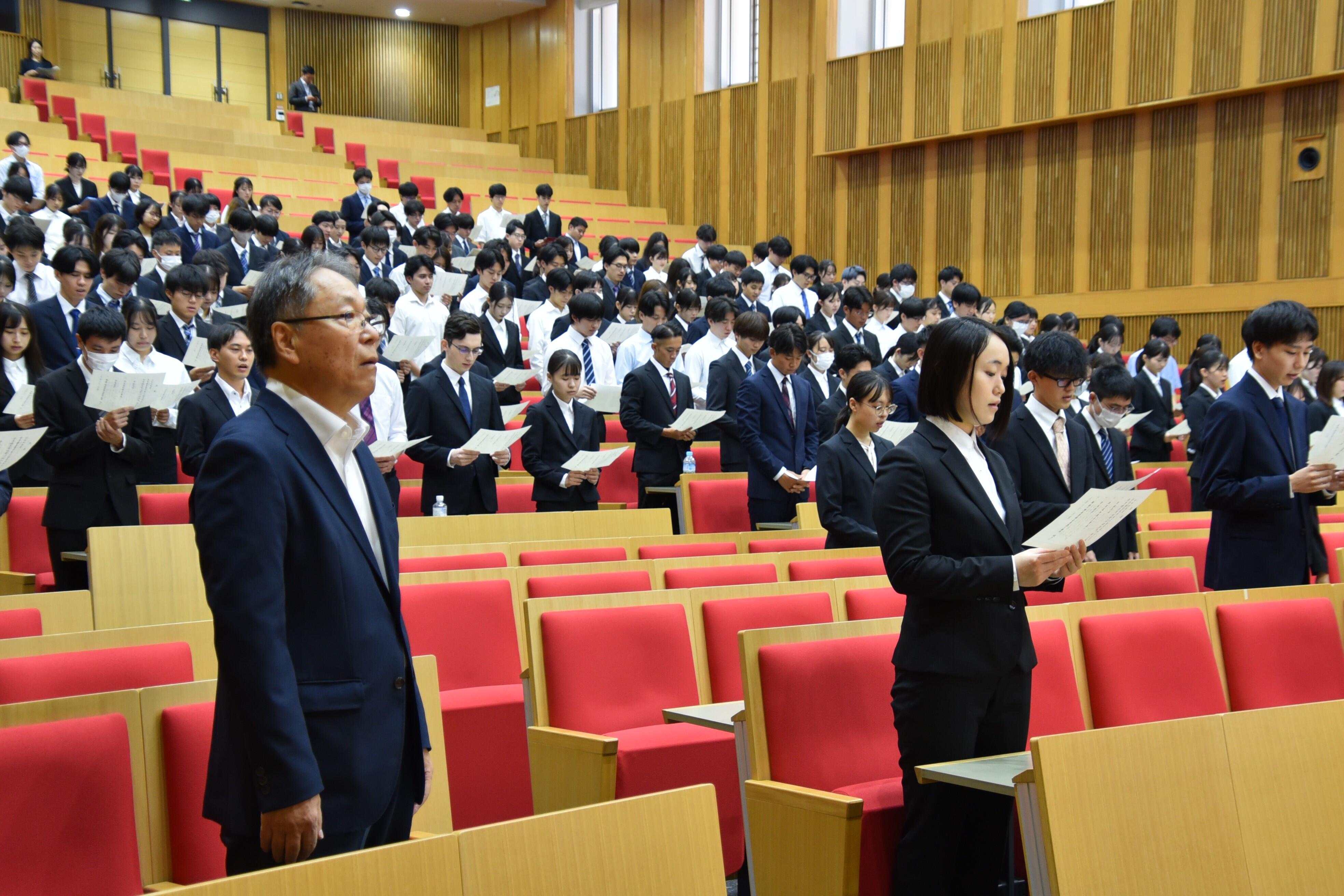 学歌を斉唱する出席者