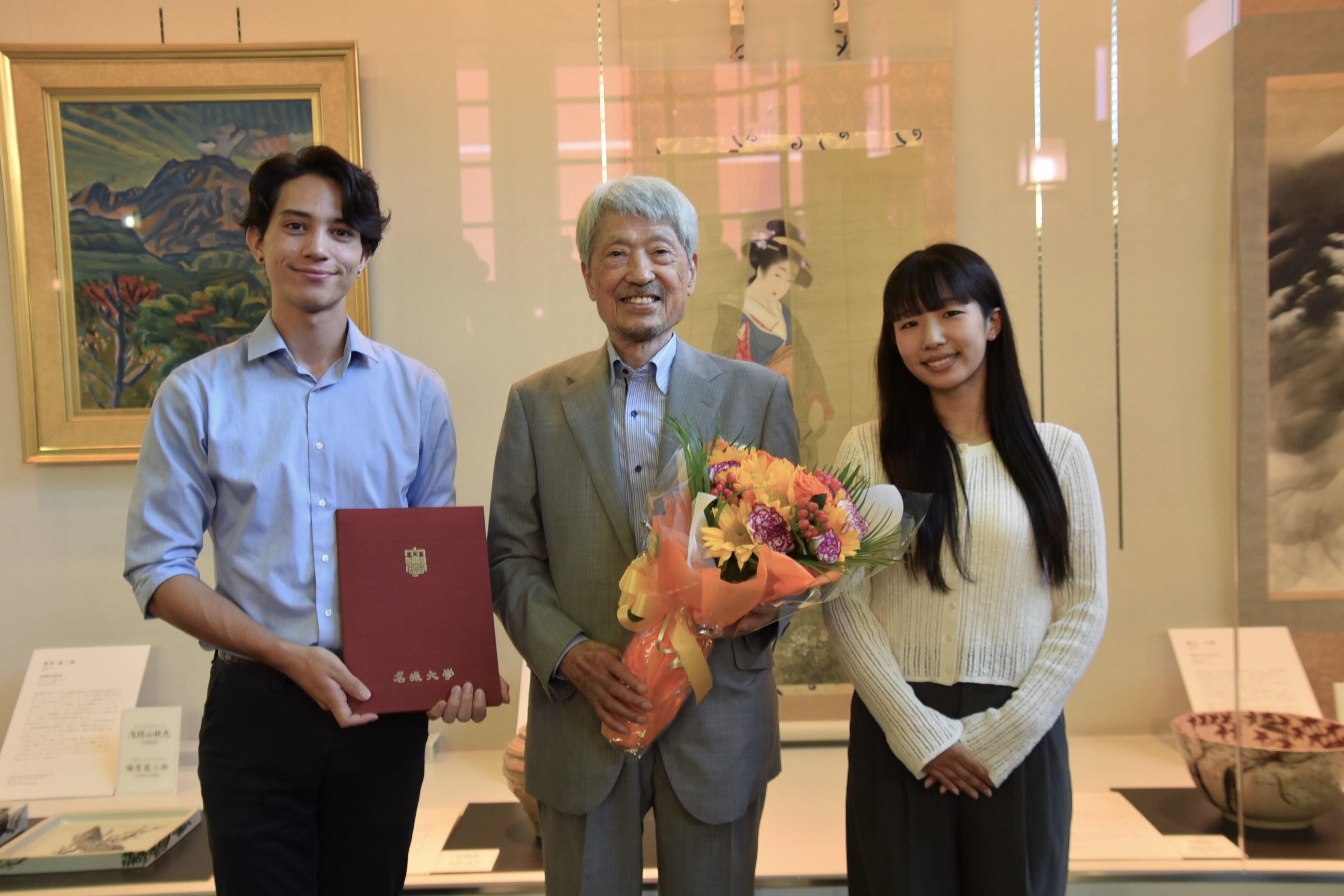 花束を贈呈した小池さん（右）、前田さん（左）と長谷川顧問