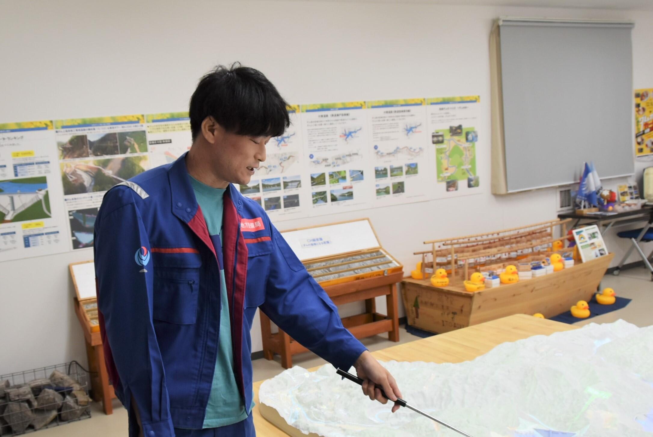 模型で工事状況を説明する大越さん