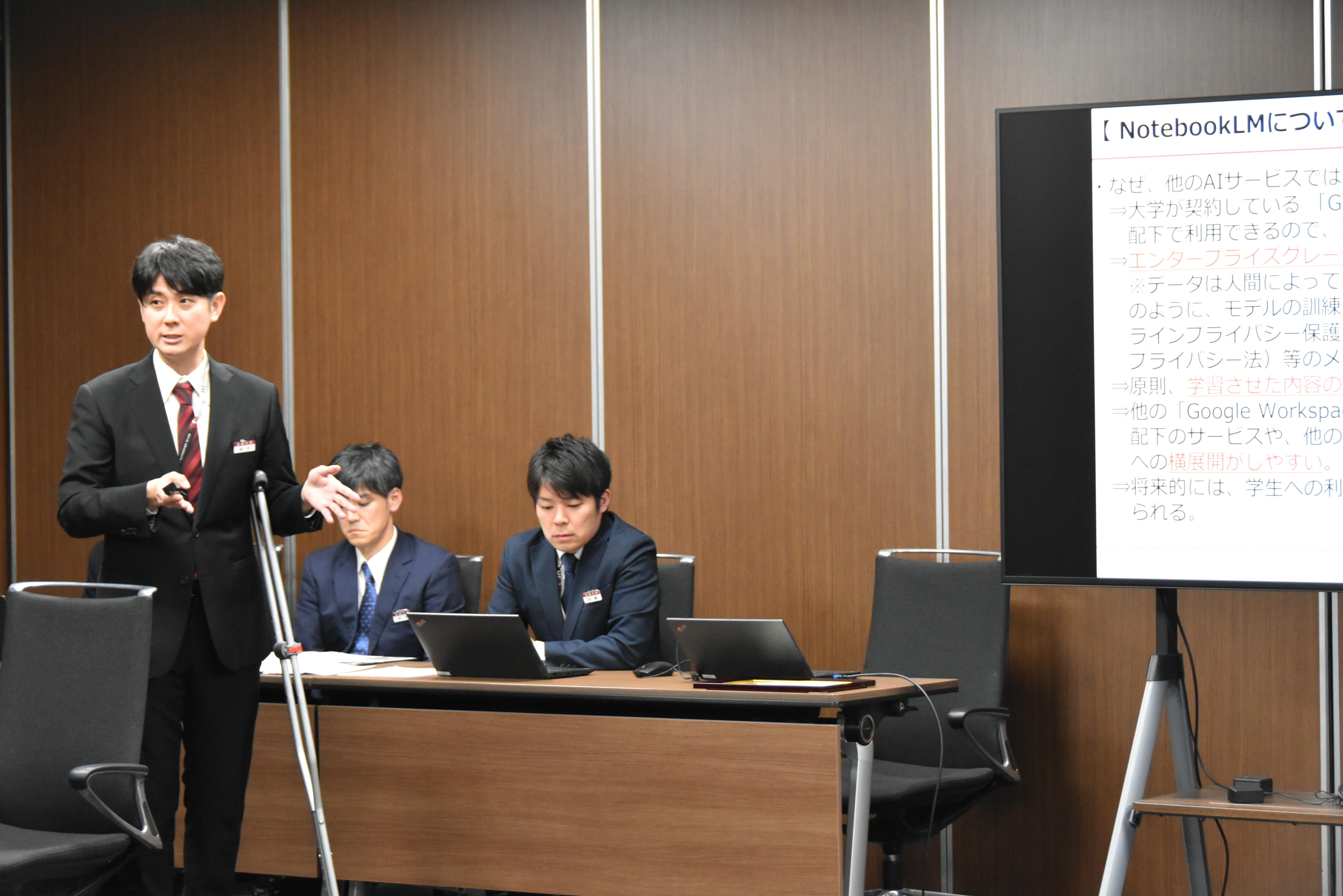 Chatbotの実演を交えて説明する金丸さんと加藤さん（後列右）