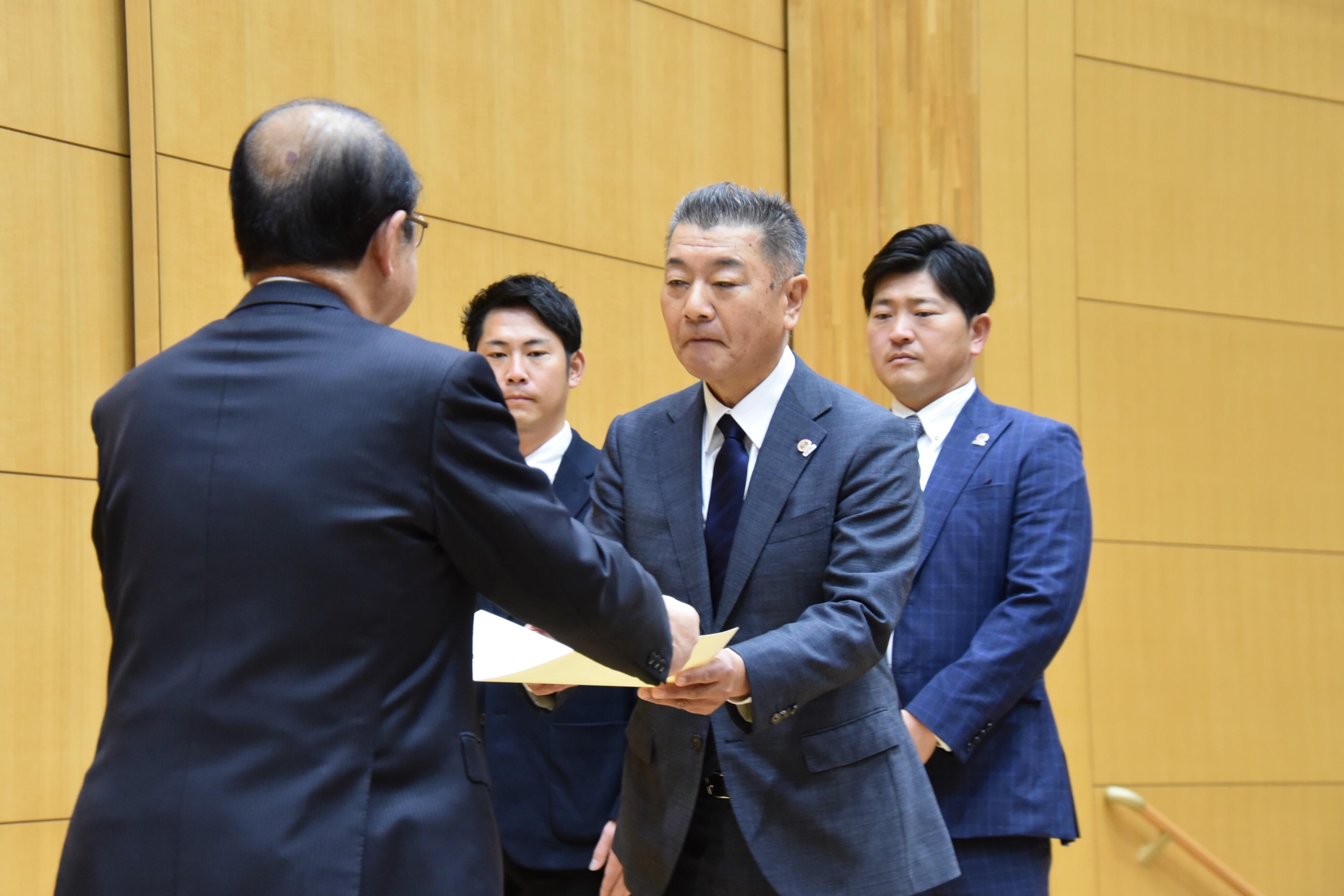 表彰状を受け取る安江前監督