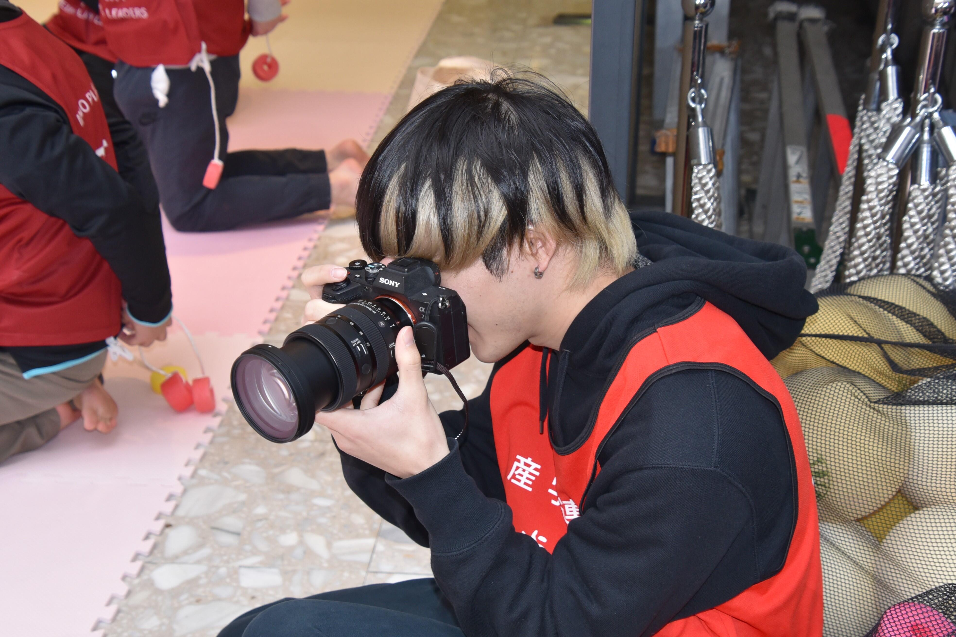 子どもたちの元気な姿を撮影する学生