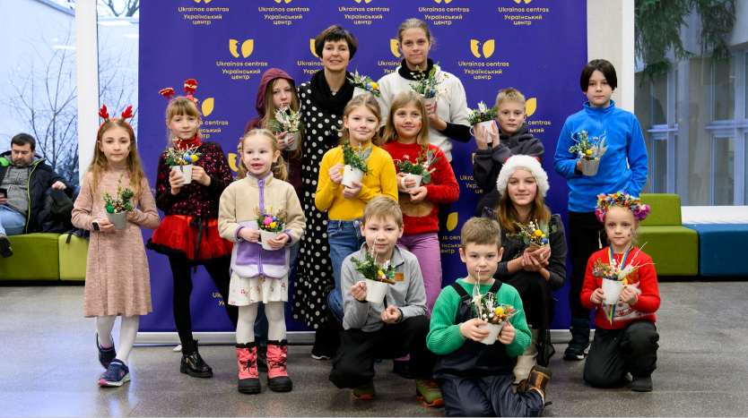 完成したクリスマス・デコレーションとともに立つウクライナ難民の子どもたち
